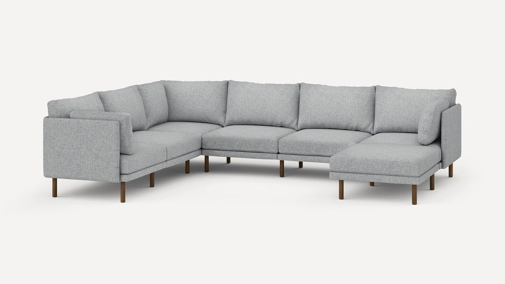 Light gray fabric sectional sofa with clean lines, wooden legs, and cushioned back and seat in an L-shape design.