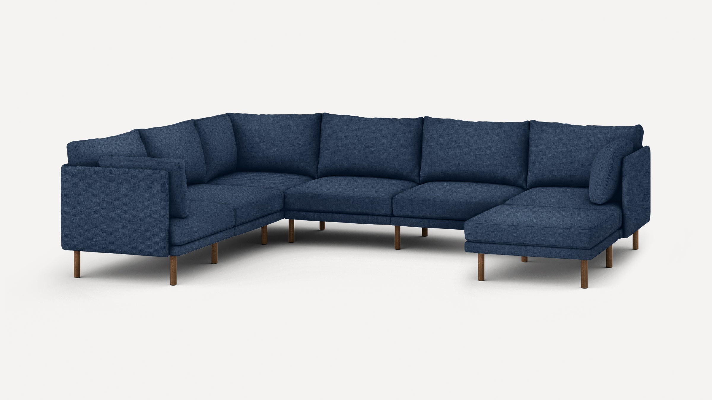 Large modern navy blue sectional sofa with wooden legs, featuring a corner chaise and multiple cushions for comfortable seating.