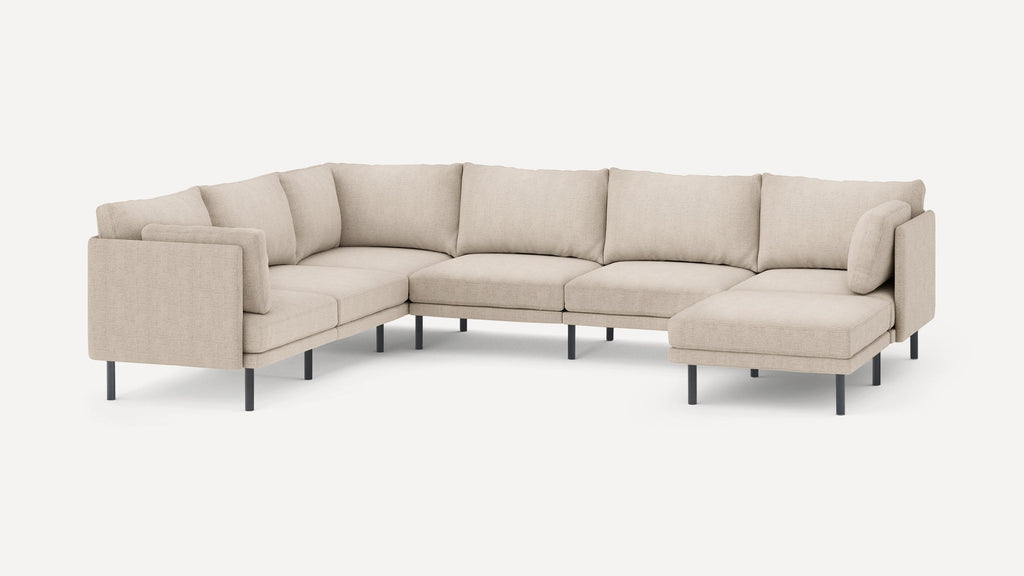 Beige fabric U-shaped sectional sofa with sleek black metal legs and multiple plush back and side cushions.