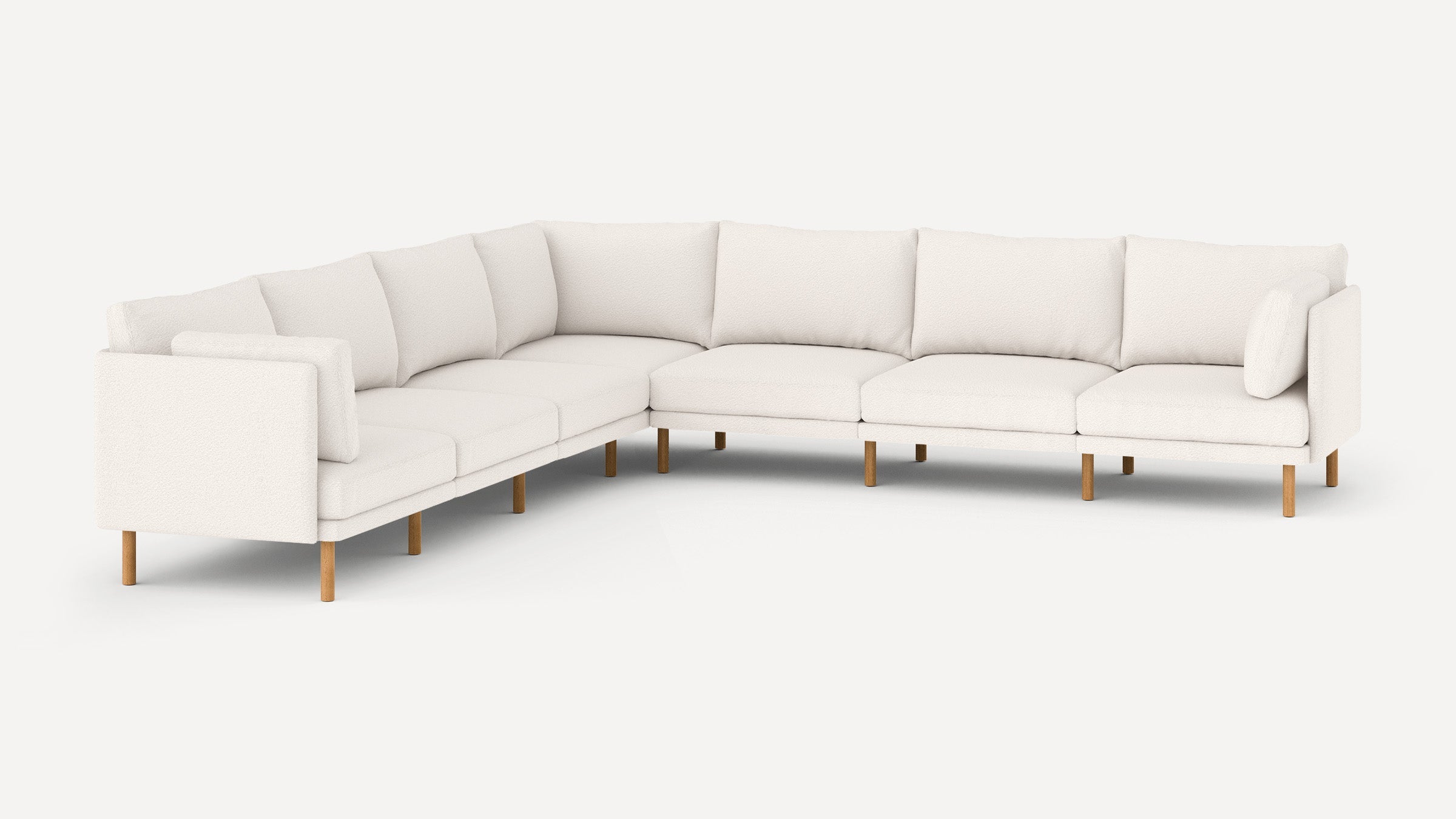 Modern L-shaped sectional sofa in white fabric with wooden legs, featuring multiple cushions for added comfort.