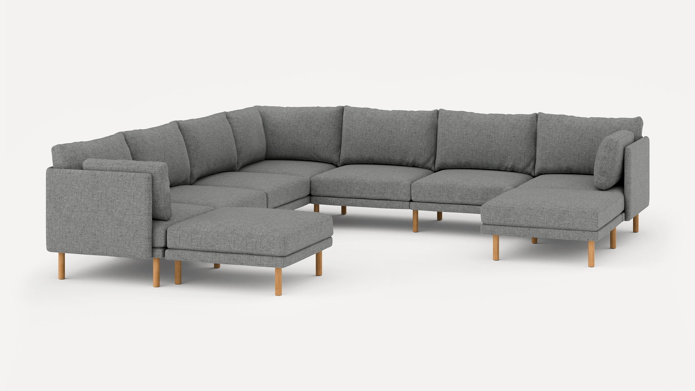 Modern L-shaped gray fabric sectional sofa with wooden legs, featuring multiple back cushions and an attached ottoman on a plain white background.