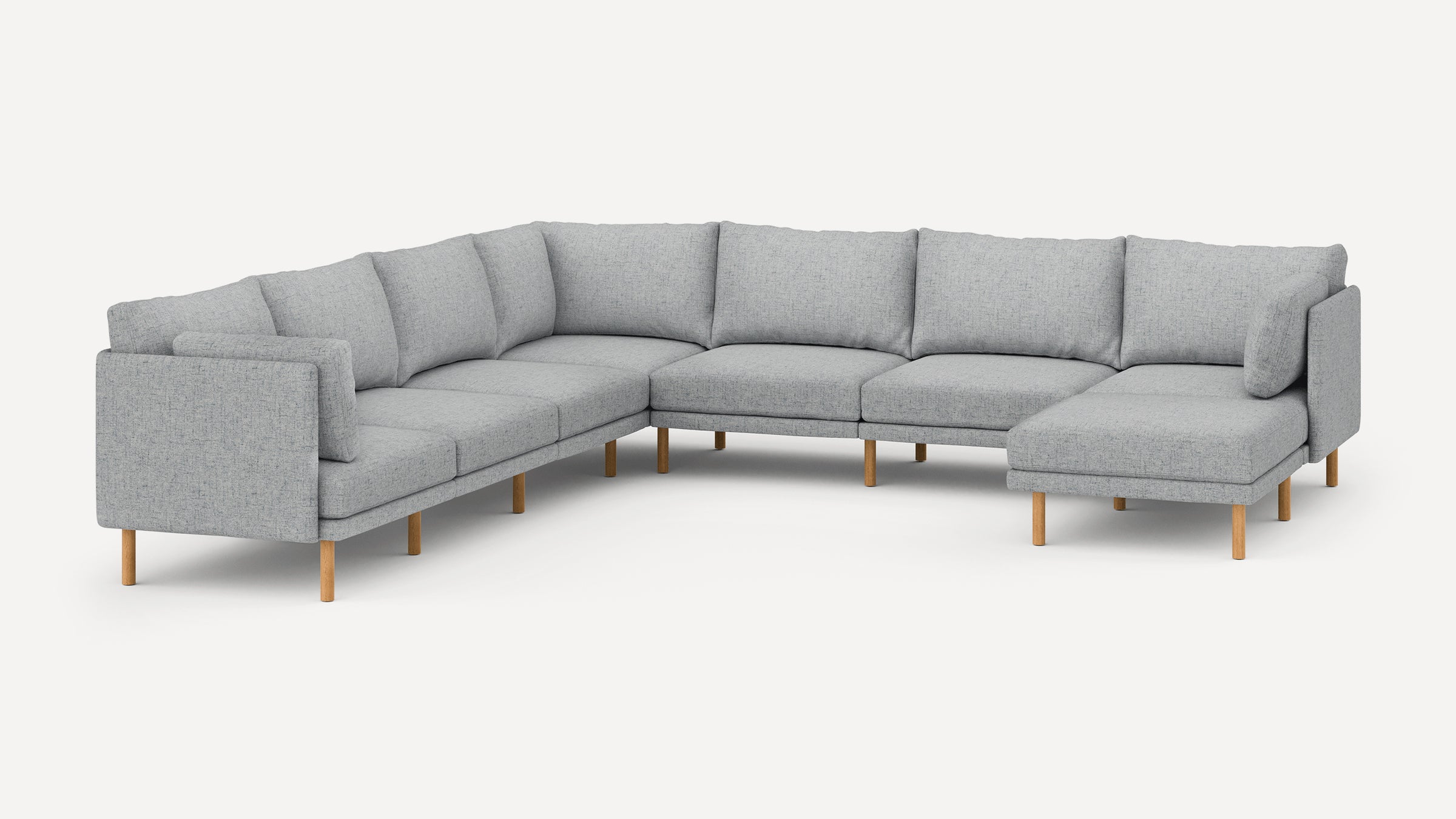 Large modern L-shaped sectional sofa in light gray fabric with wooden legs and cushioned backrests.