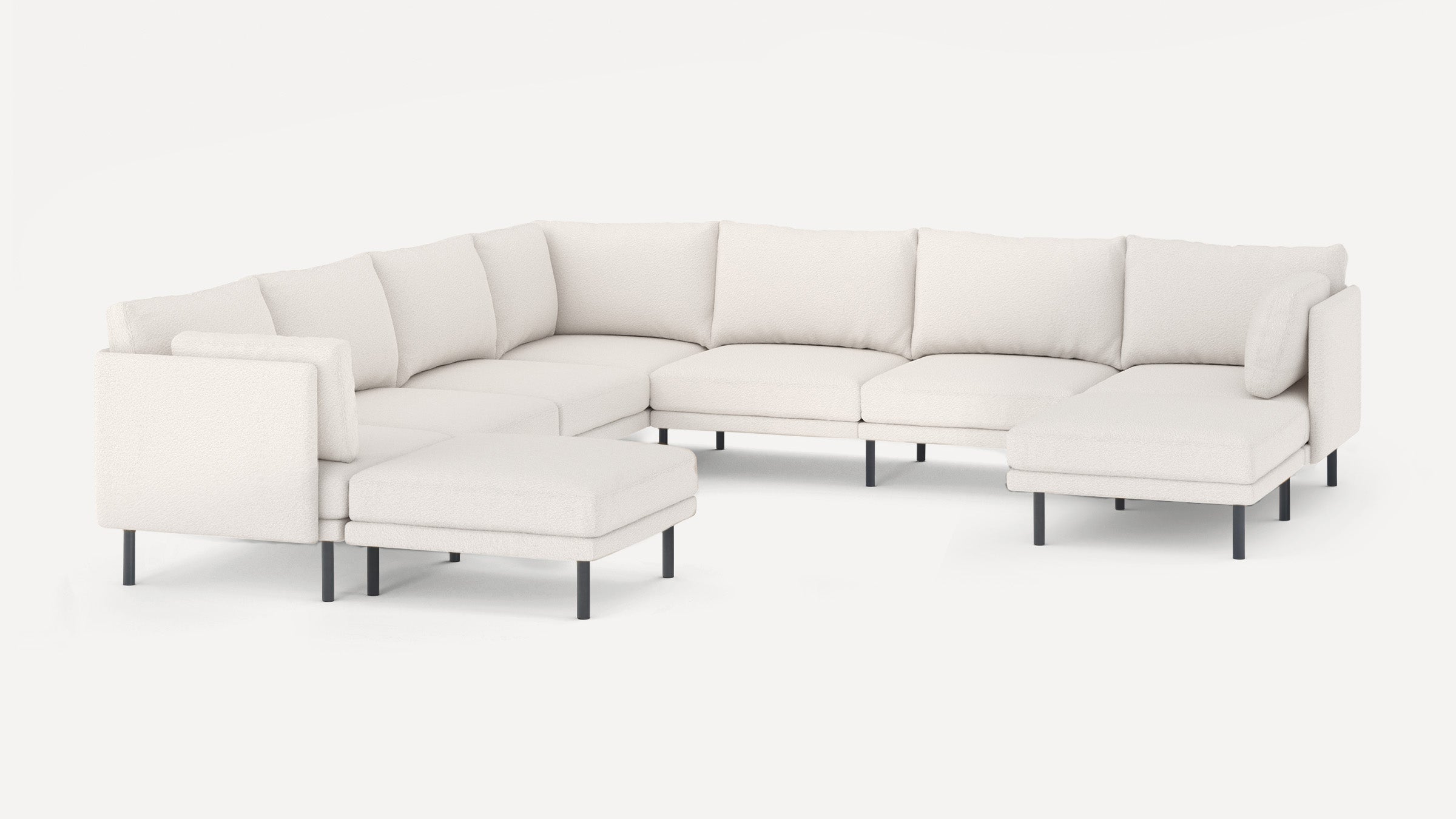 Large modern white sectional sofa with black metal legs, featuring multiple cushioned seats and backrests, including a chaise lounge and ottoman.