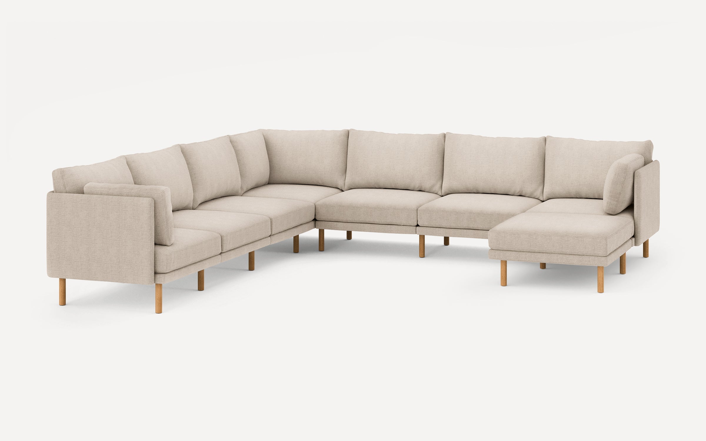 Beige L-shaped sectional sofa with wooden legs, featuring plush cushions and a modern minimalist design.