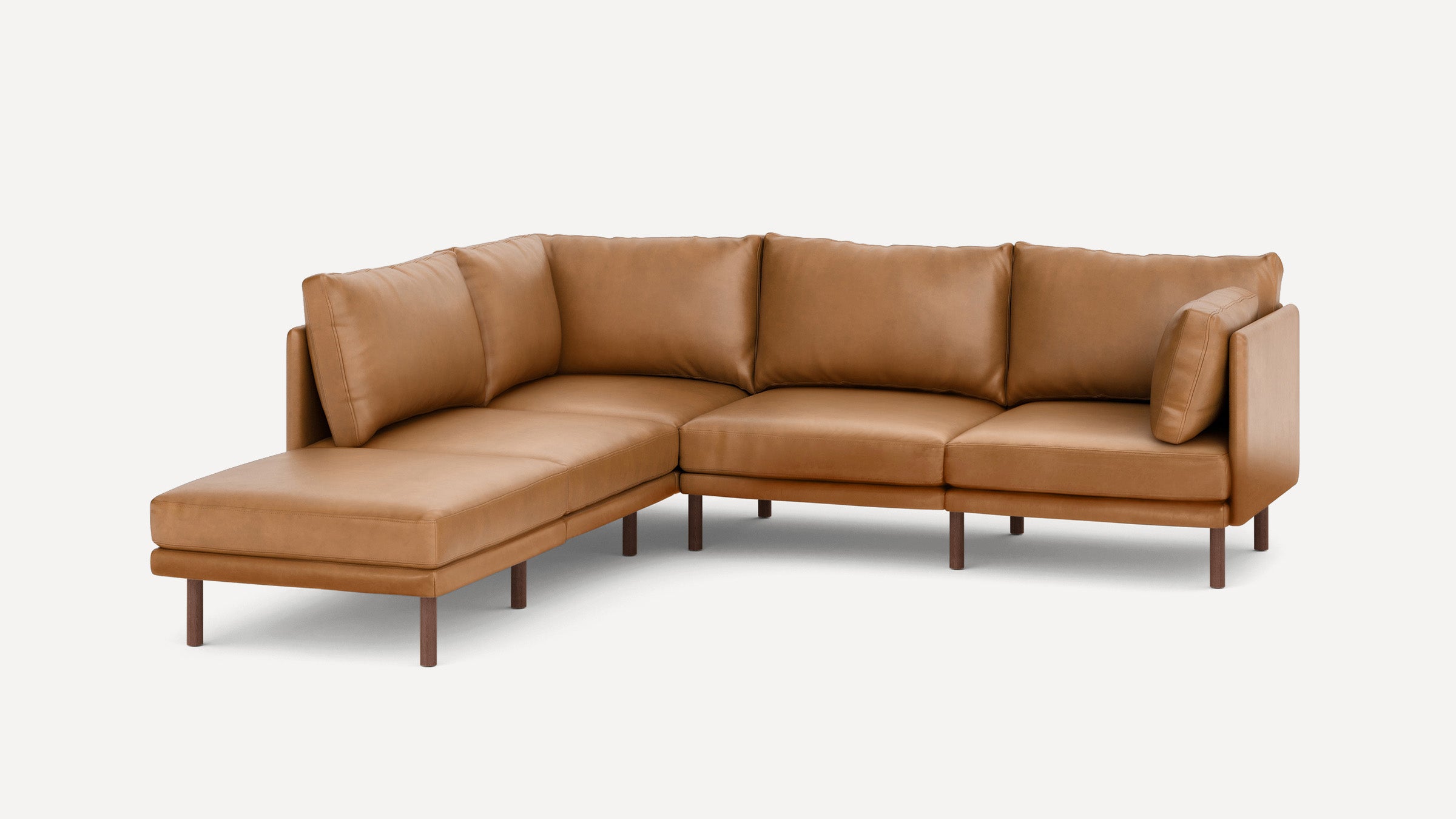 Modern L-shaped sectional sofa in tan leather with clean lines, cushioned seats, and wooden legs on a plain background.