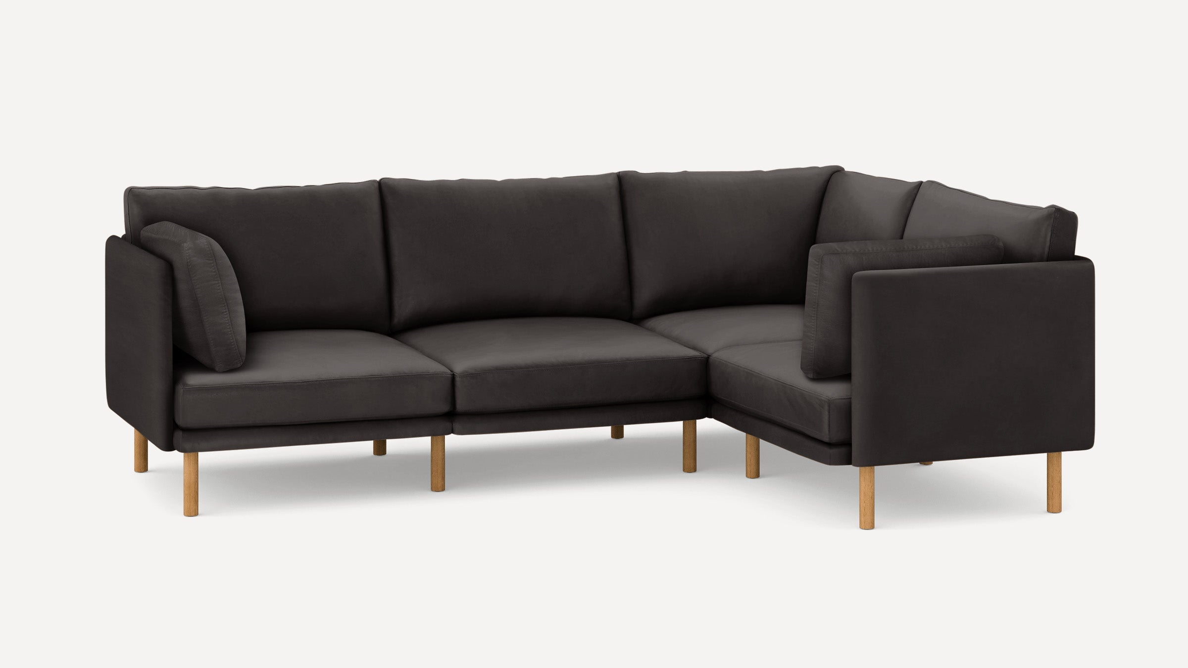 Dark gray L-shaped sectional sofa with wooden legs and matching cushions on a plain white background.