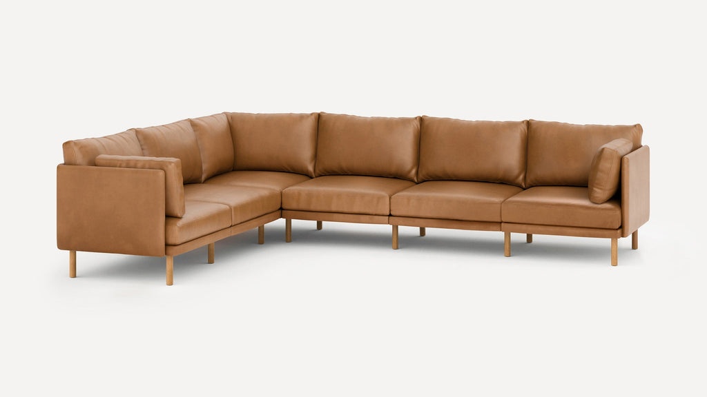 L-shaped modern sectional sofa with tan leather upholstery, wooden legs, and padded cushions for comfort and style.