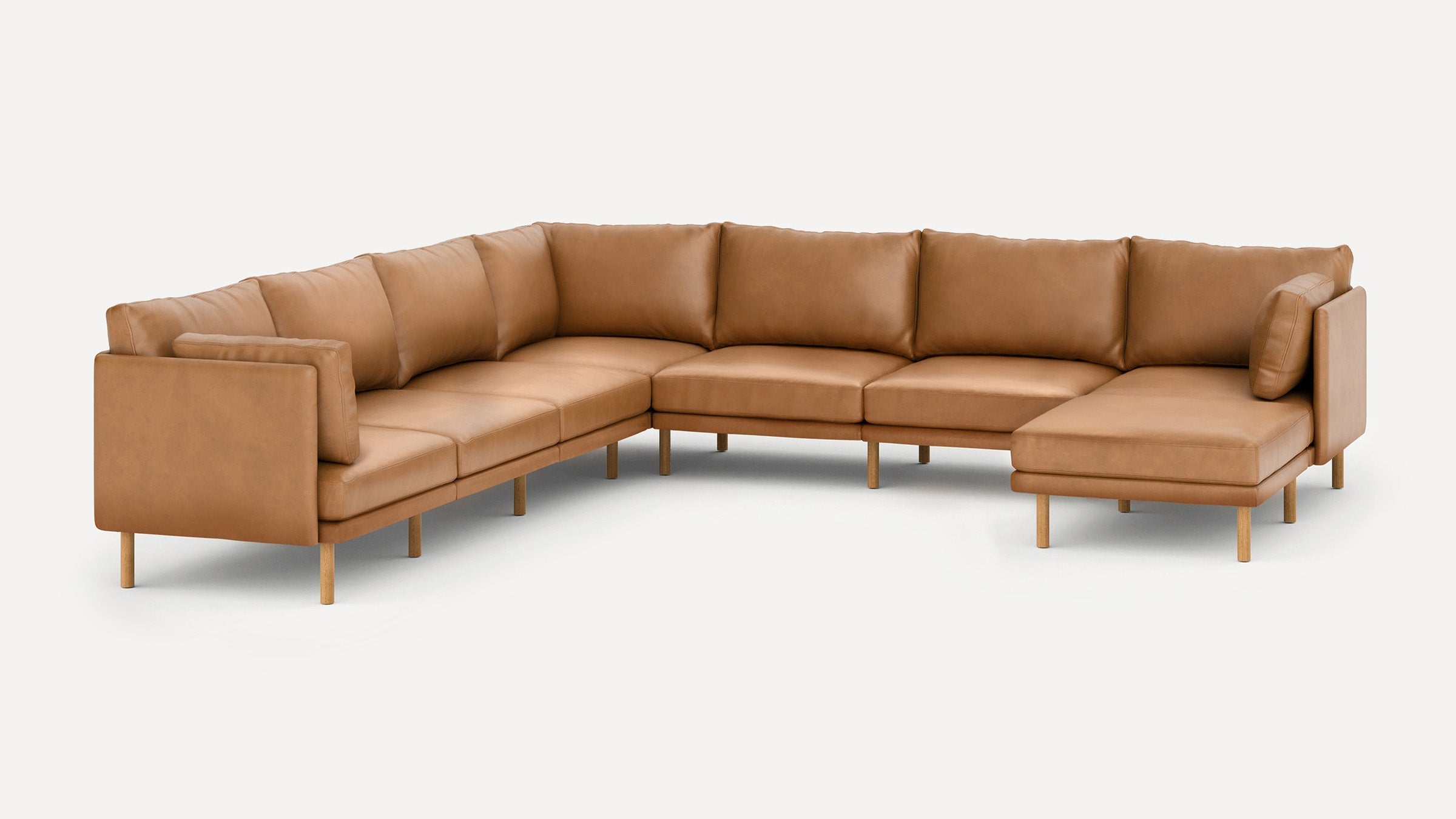 Modern L-shaped sectional sofa with tan leather upholstery and wooden legs, featuring cushioned seats and backrests for comfort.