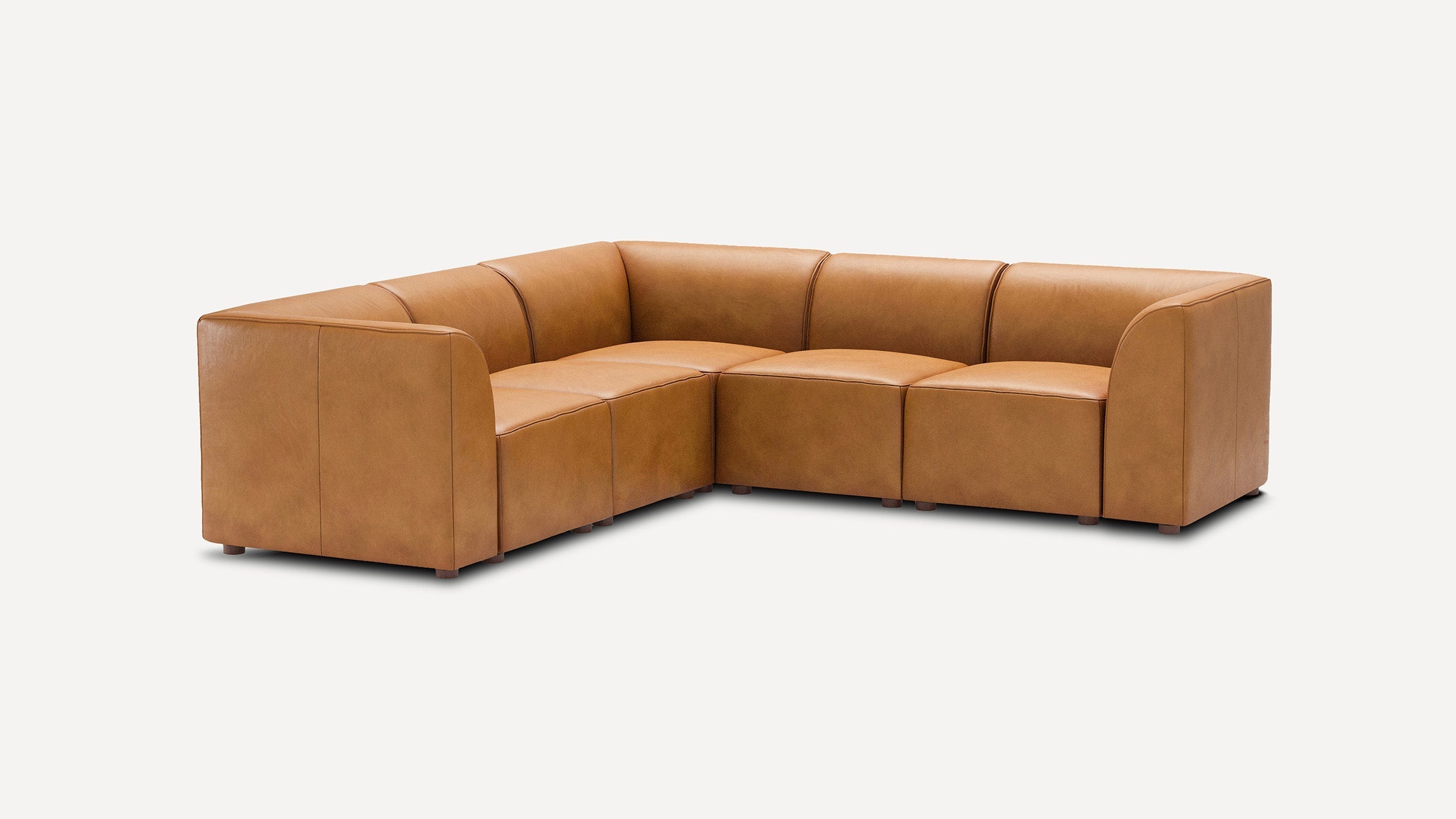 modern l - shaped tan leather sectional sofa with curved backrests and matching ottoman, featuring a sleek design on the right side