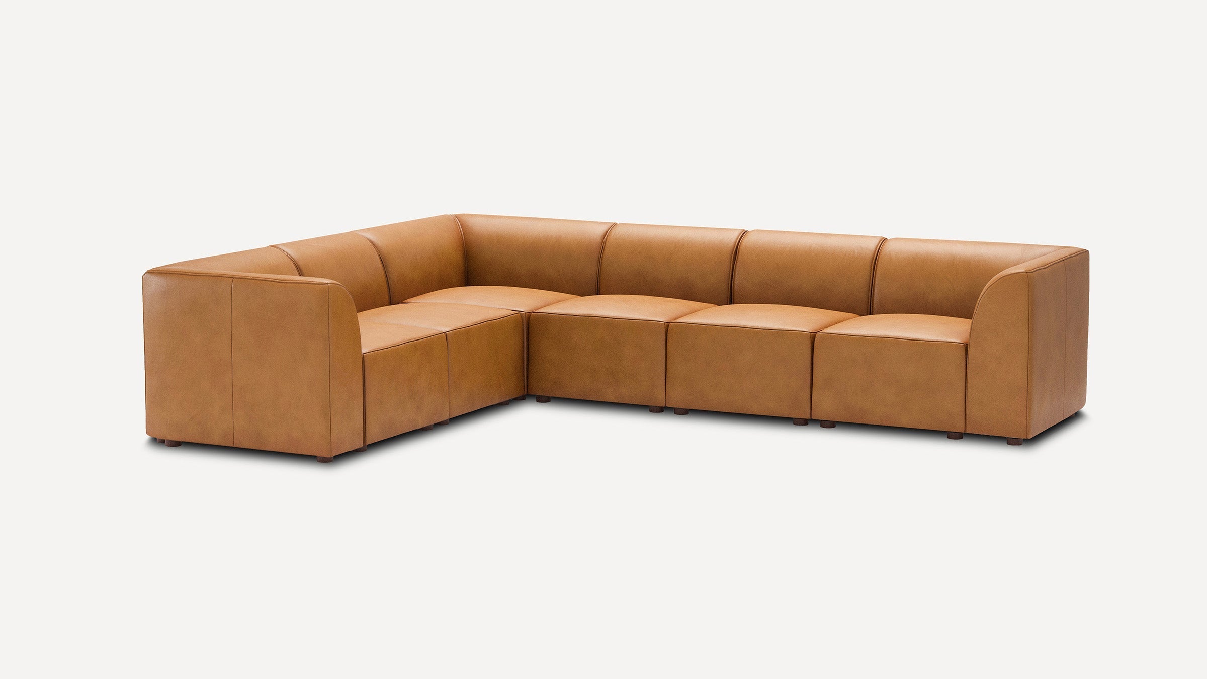 modern l - shaped tan leather sectional sofa with four seats and a rectangleed backrest, isolated on a white background
