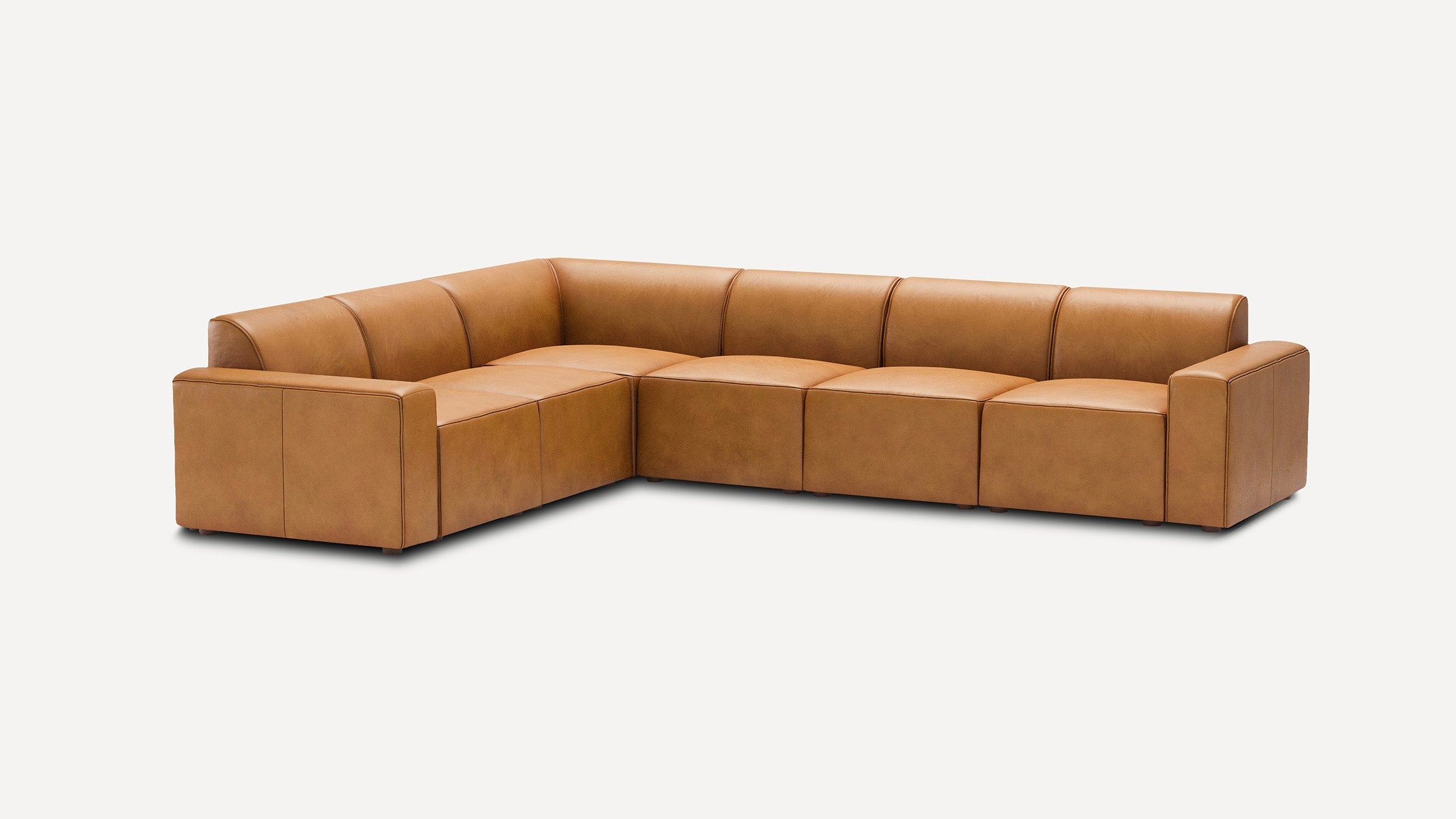modern l - shaped sectional sofa in light brown leather with matching ottoman, featuring tapered seats and a sleek backrest