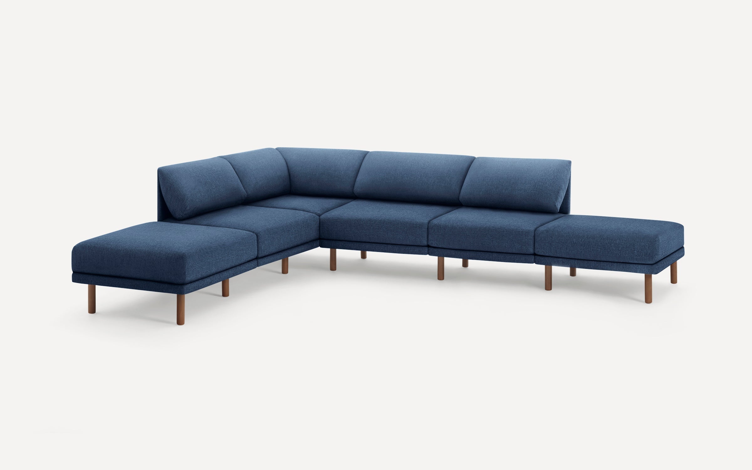 Modern L-shaped sectional sofa upholstered in blue fabric with wooden legs, featuring cushioned backrests and minimalist design.
