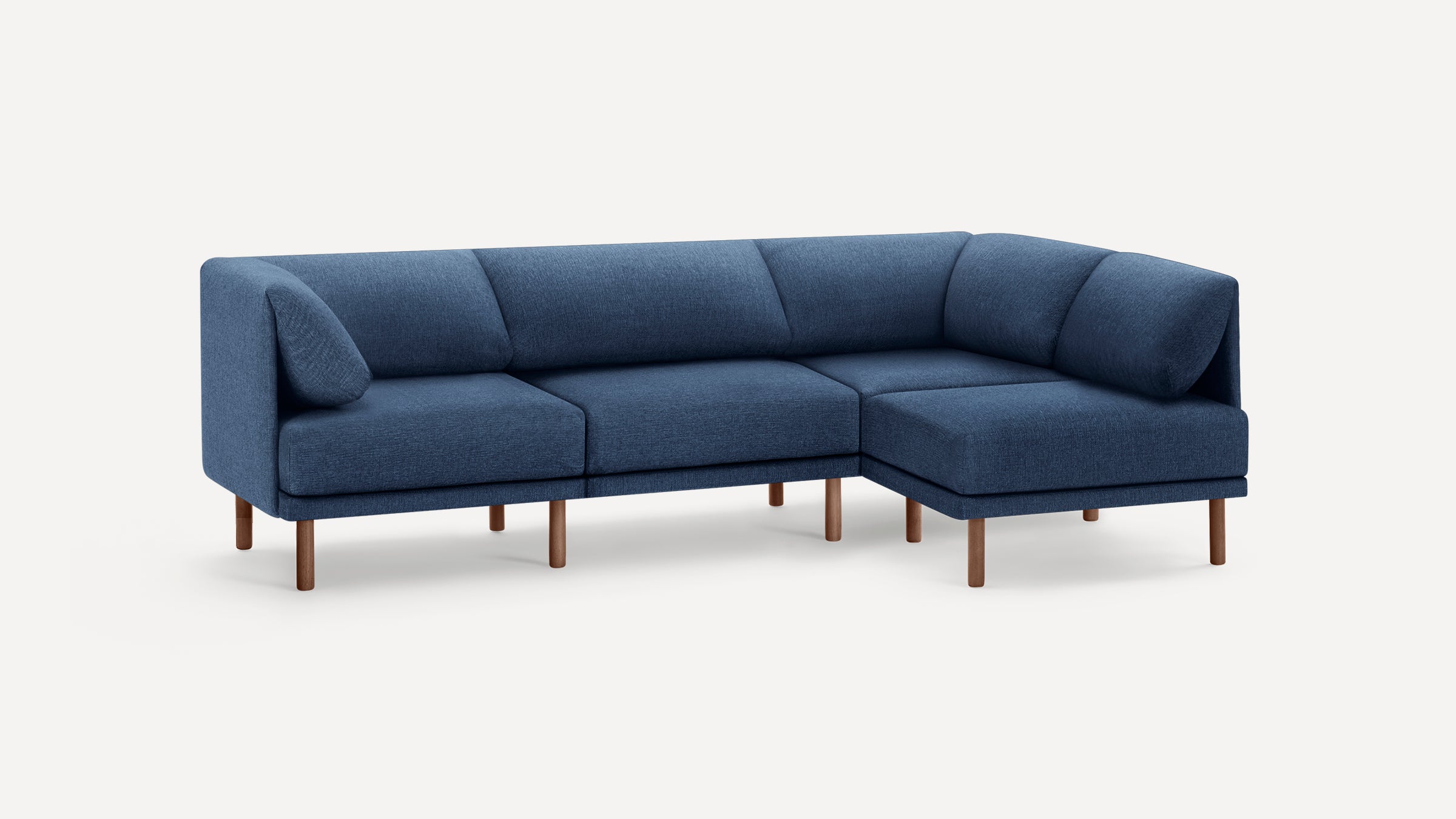 Modern navy blue fabric sectional sofa with wooden legs, L-shaped design, and cushioned backrest and armrests.