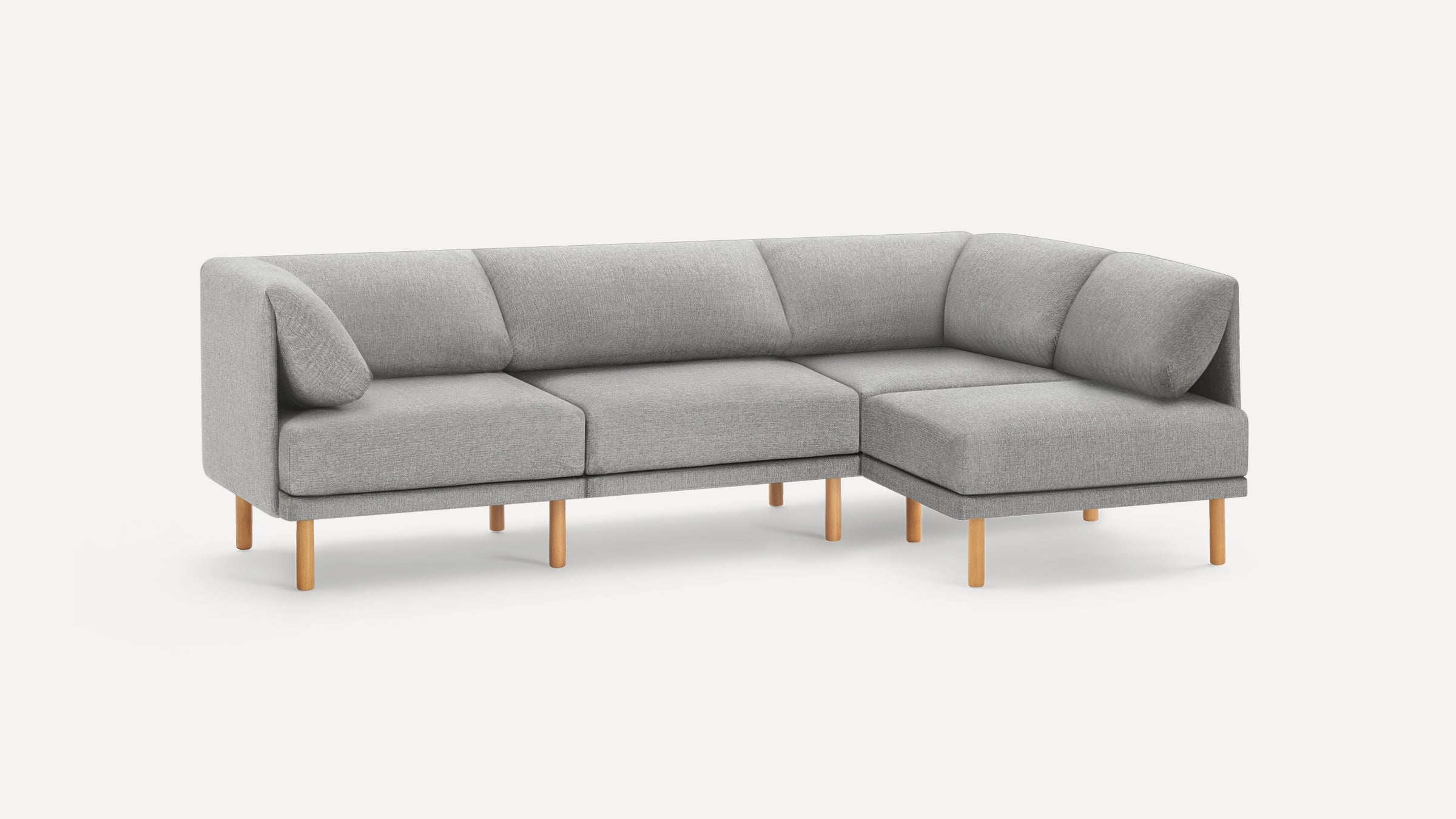 Modern L-shaped gray fabric sofa with wooden legs, featuring cushioned seats and angled backrests for comfortable lounging.