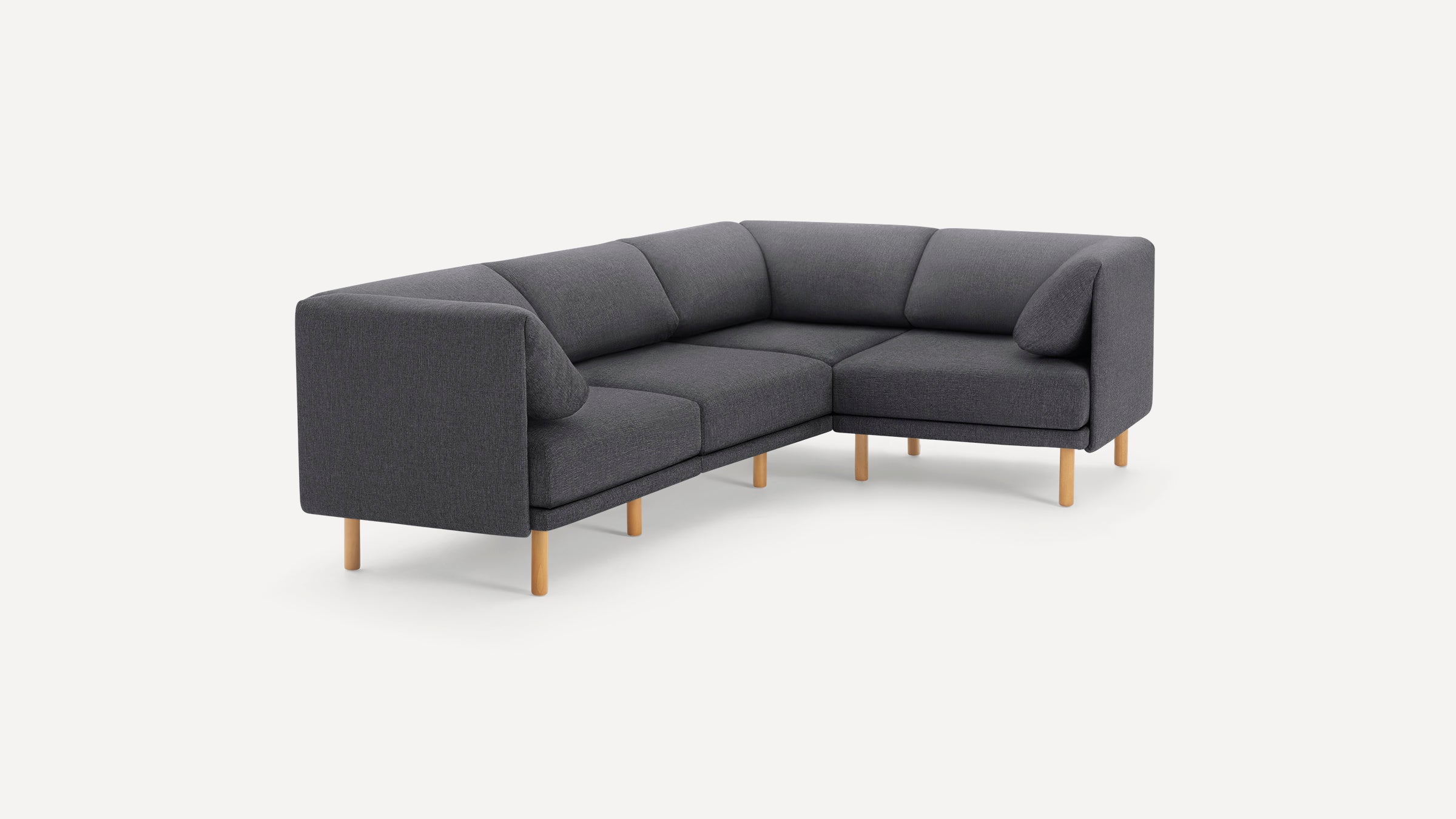 Modern L-shaped sectional sofa with dark gray fabric upholstery and light wooden legs, featuring clean lines and cushioned backrests.