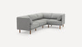 Modern L-shaped grey fabric sofa with wooden legs, featuring cushioned seats and backrests, and two side pillows.