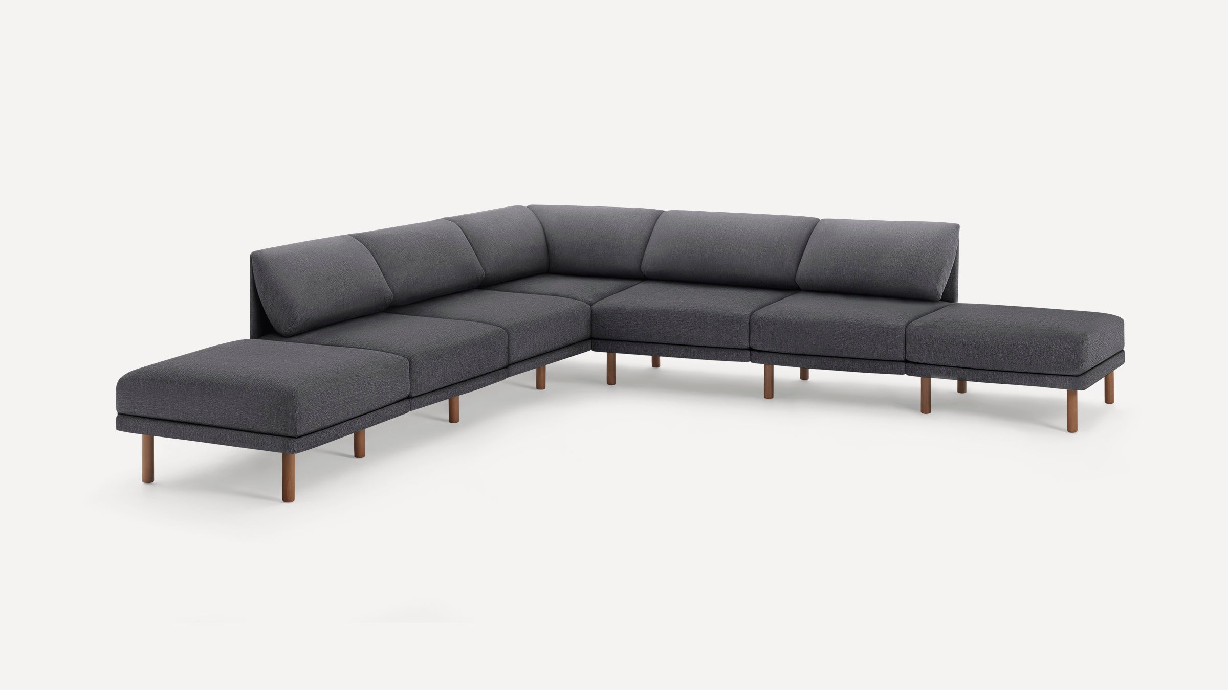 Modern sectional sofa with dark gray upholstery and wooden legs, arranged in an L-shape with cushioned backrests and seats.
