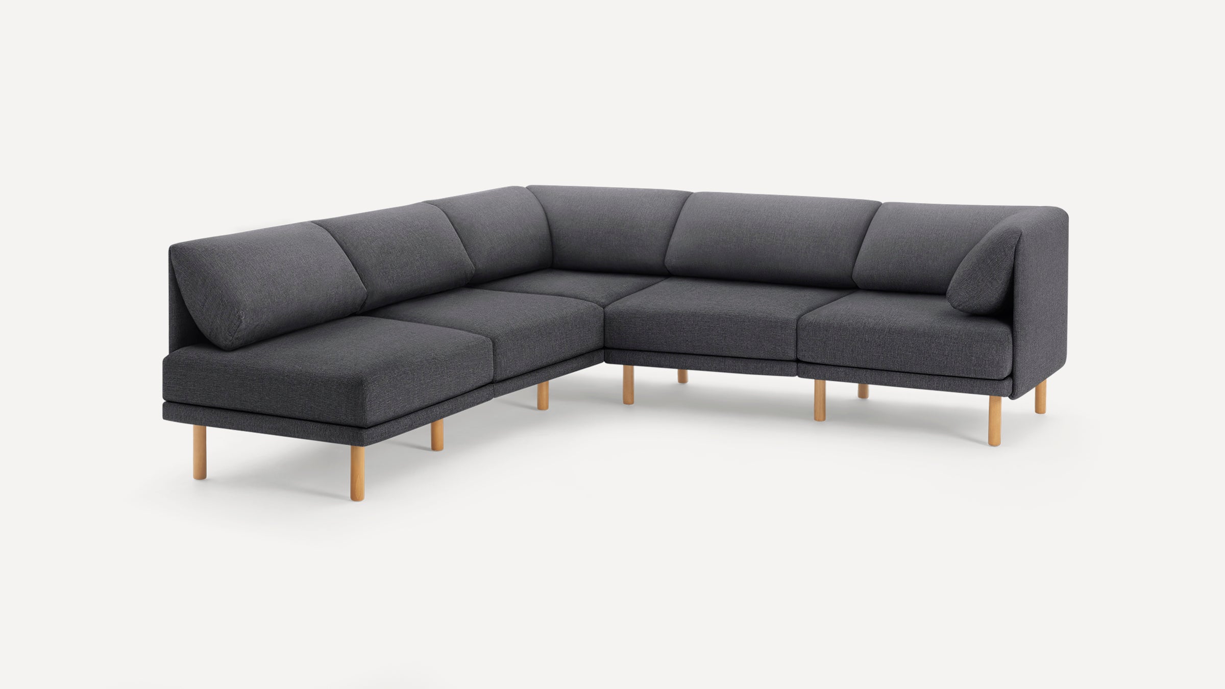 Modern L-shaped dark gray fabric sectional sofa with cushioned backrests and light wooden legs on a white background.