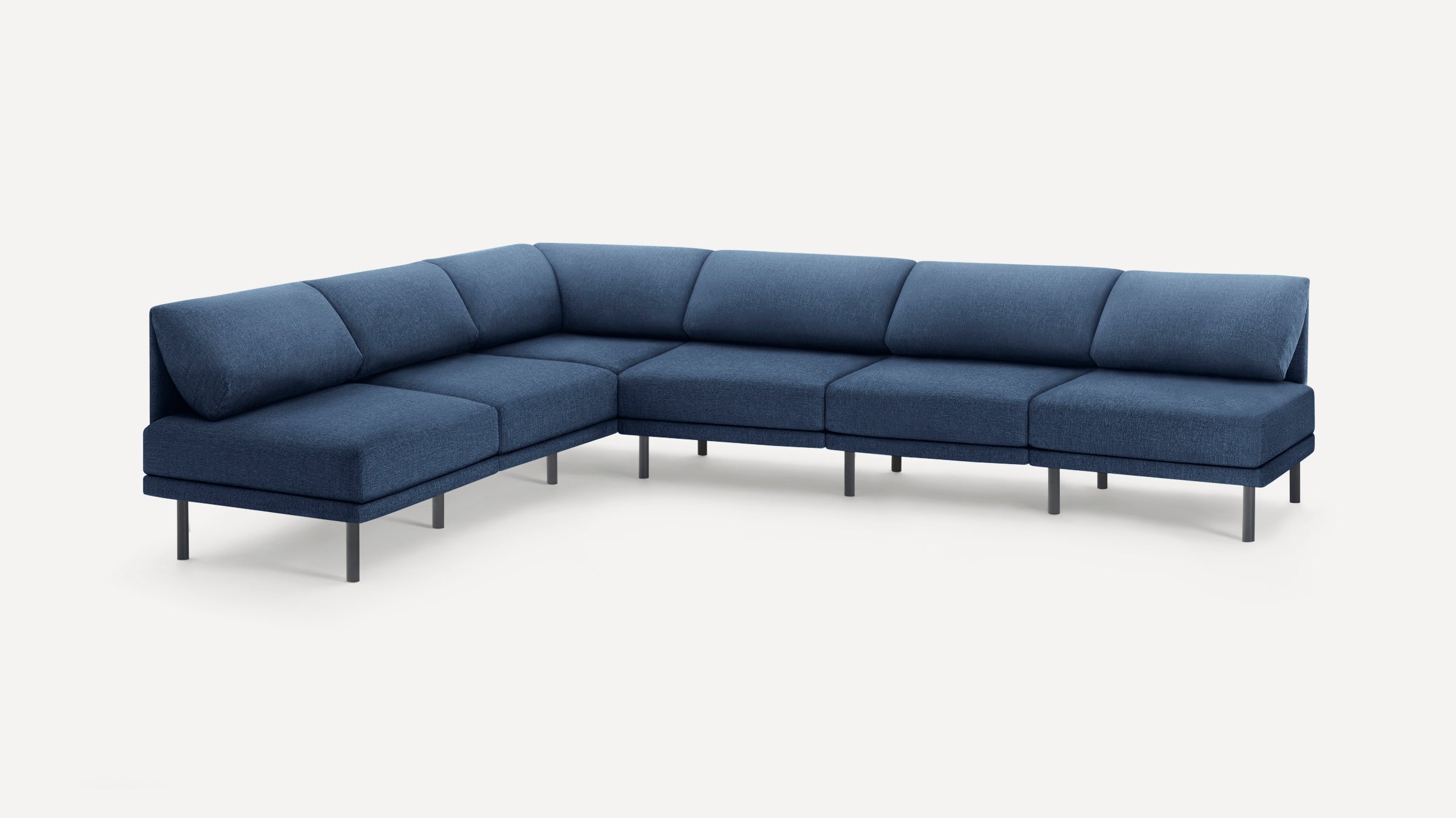 Modern L-shaped sectional sofa in deep blue fabric with low backrest and slim black metal legs on white background.