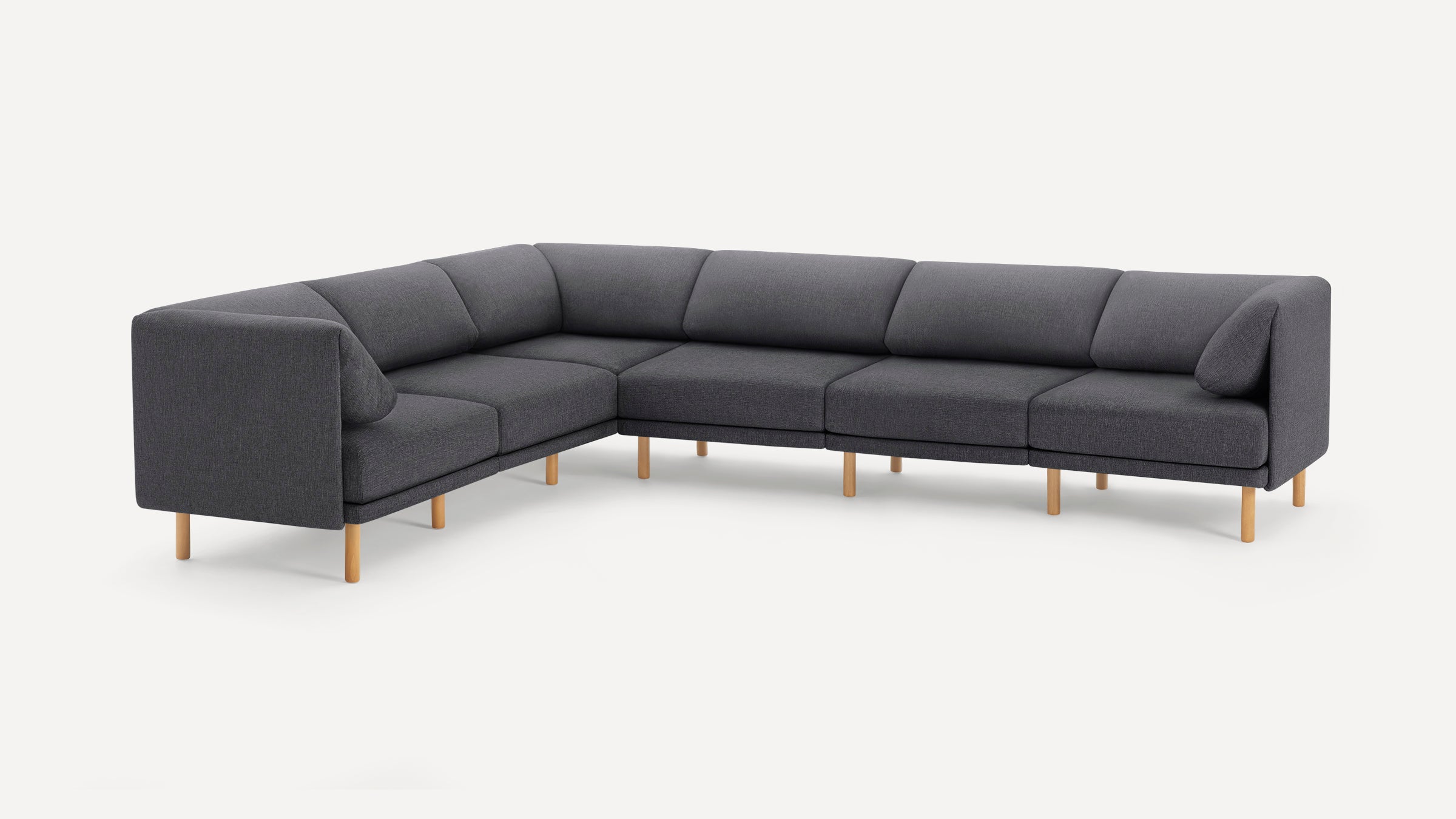 Dark gray L-shaped sectional sofa with clean lines, plush cushions, and light wood legs against a white background.