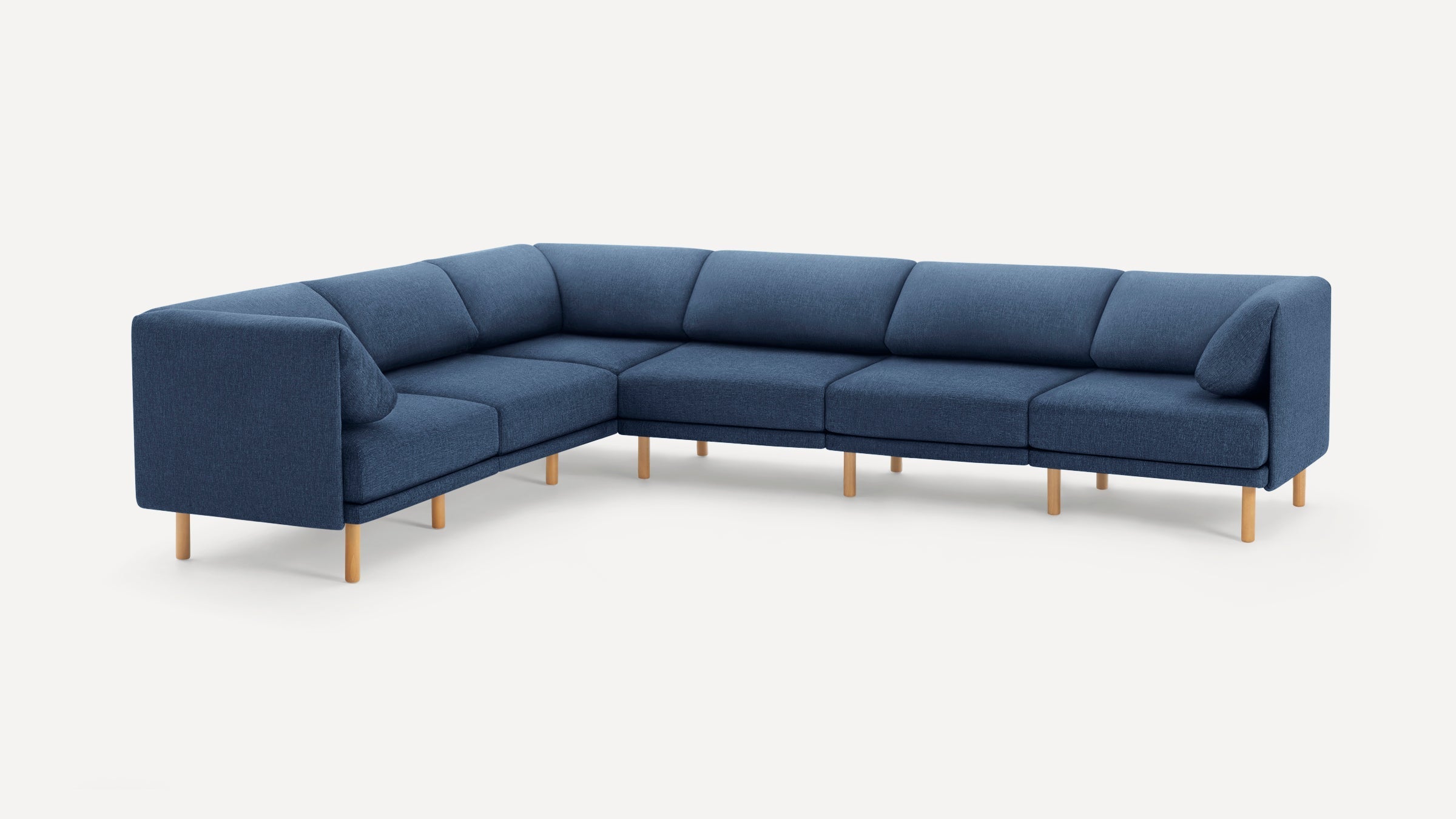 Modern L-shaped sectional sofa with deep blue fabric upholstery and light wooden legs, featuring clean lines and plush cushioning.