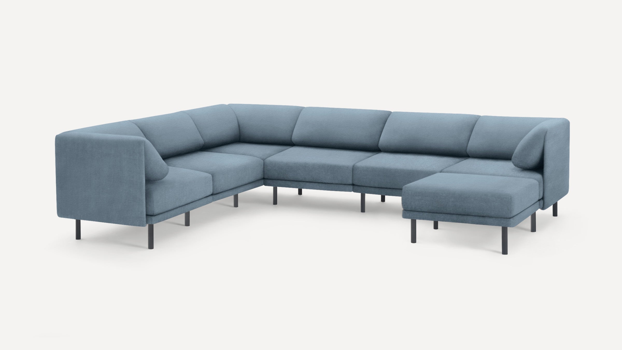 Modern L-shaped sectional sofa in muted blue upholstery with slim black metal legs and cushioned seats and backs.