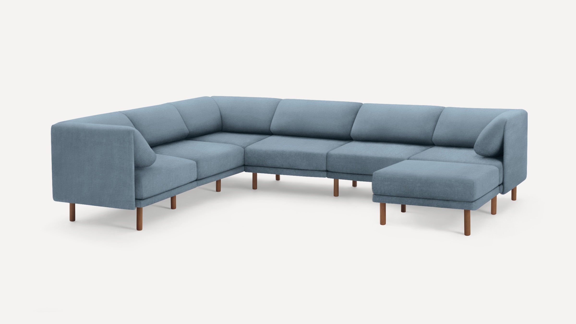 Large modern sectional sofa upholstered in blue fabric with wooden legs, featuring an L-shape and cushioned seats and backrests.