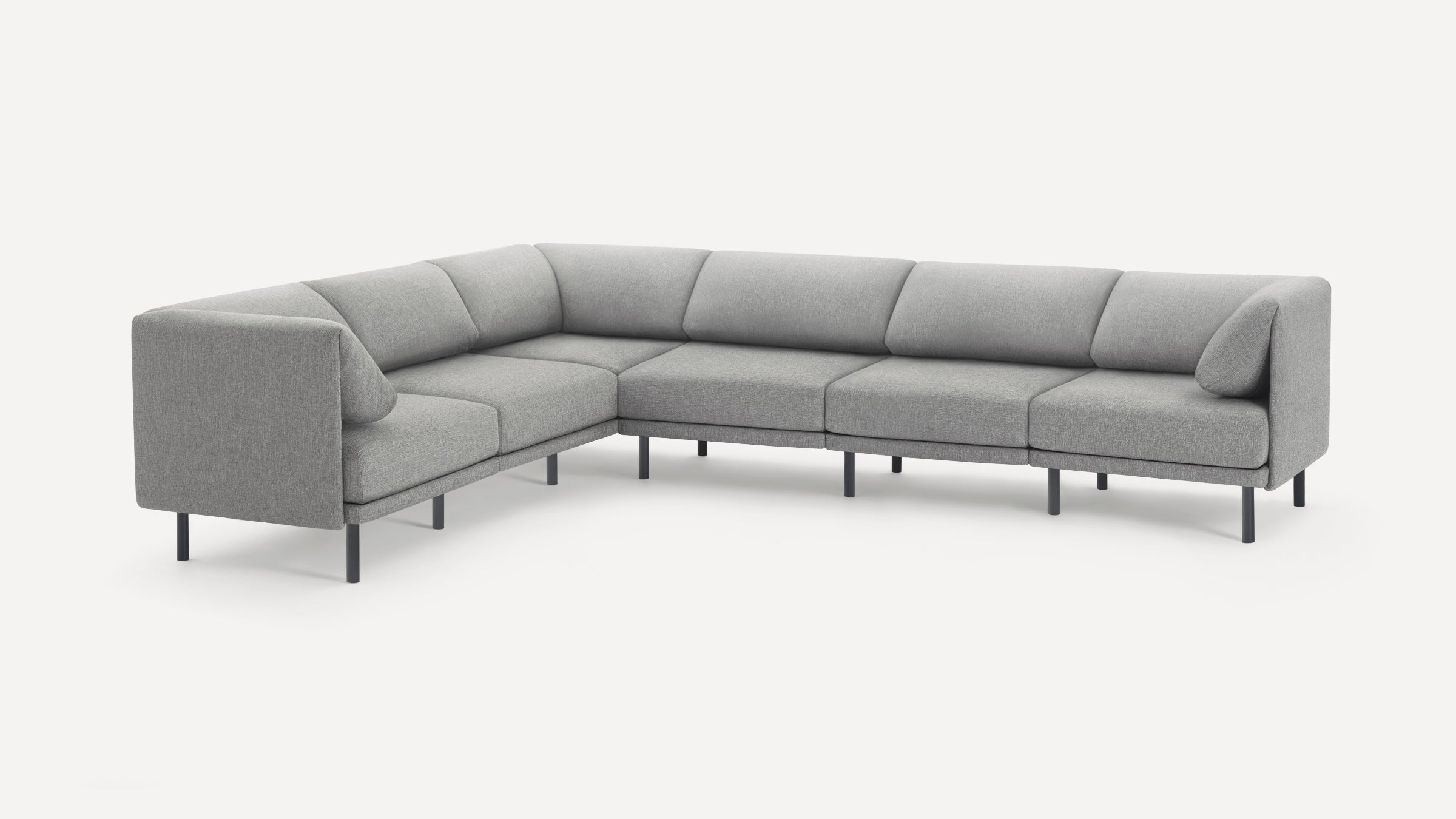 Modern L-shaped sectional sofa with grey fabric upholstery and slim black metal legs, featuring cushioned backrest and seats.