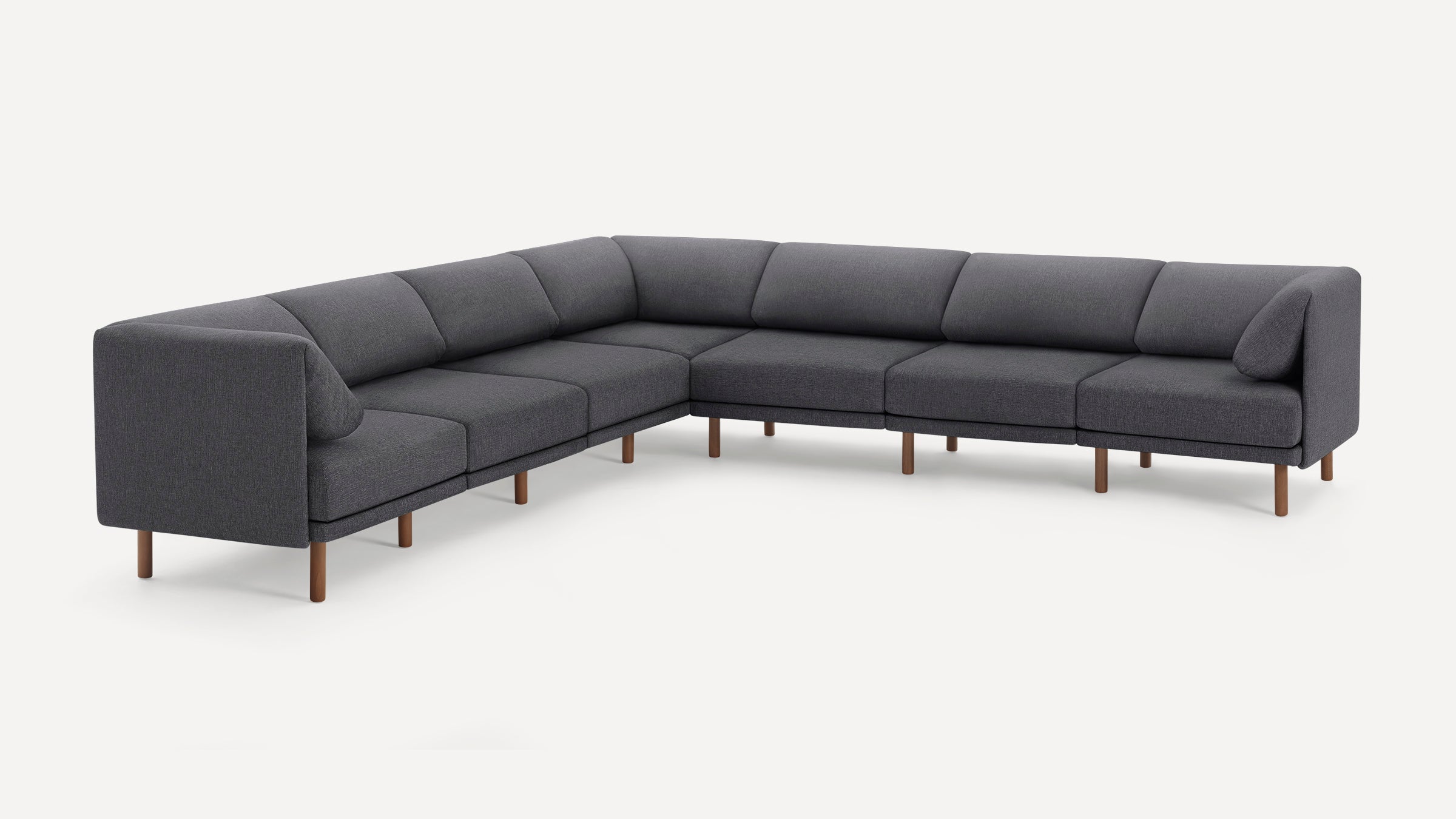 Modern dark gray fabric sectional sofa with wooden legs, featuring a minimalist design and slightly angled back cushions.