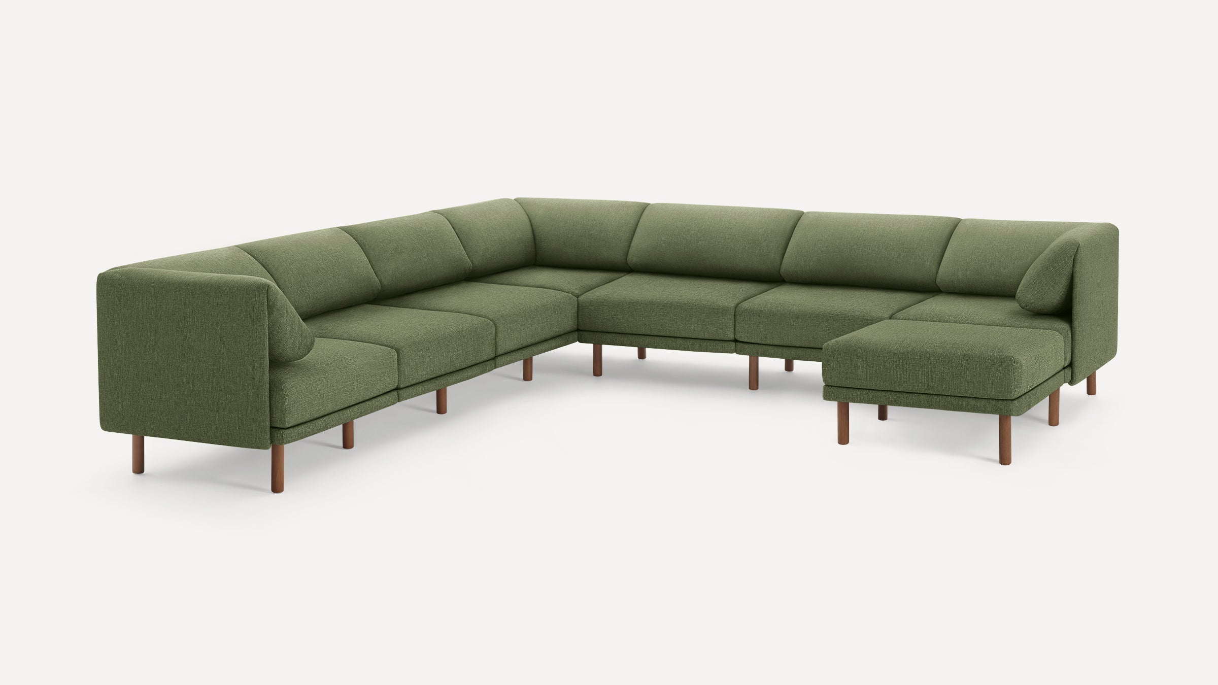 Modern L-shaped sectional sofa in olive green fabric with low backrest, clean lines, wooden legs, and accent pillows.