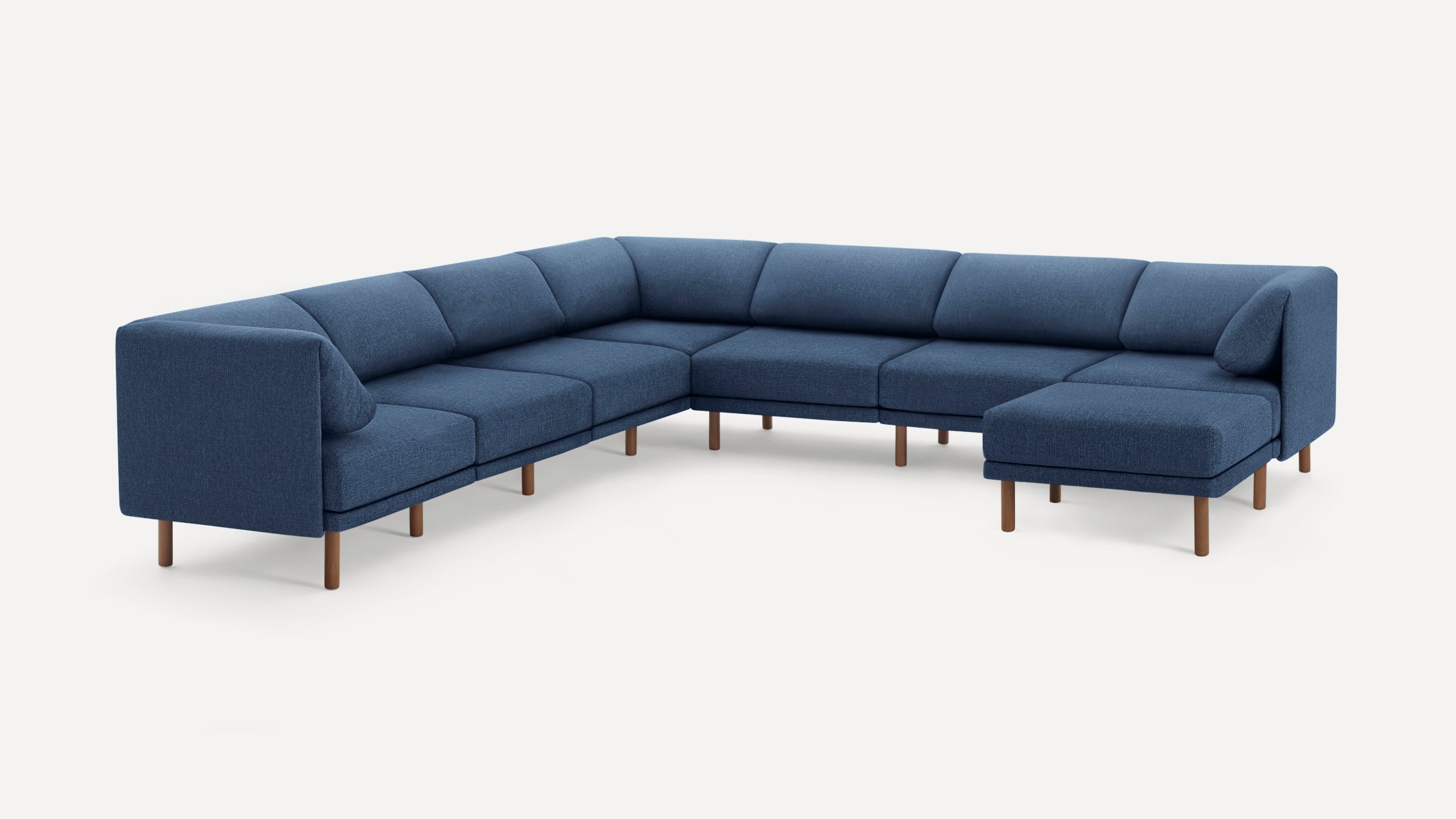 Modern large L-shaped sectional sofa with deep blue fabric upholstery and wooden legs on a white background.