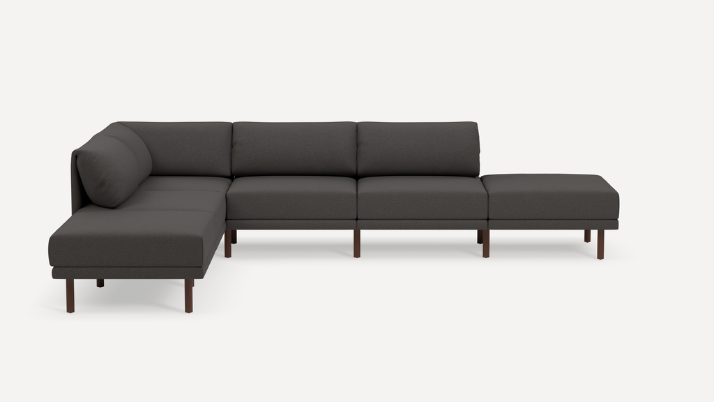 Modern L-shaped sectional sofa with dark gray fabric upholstery and slender wooden legs, featuring cushioned backrests and seats.