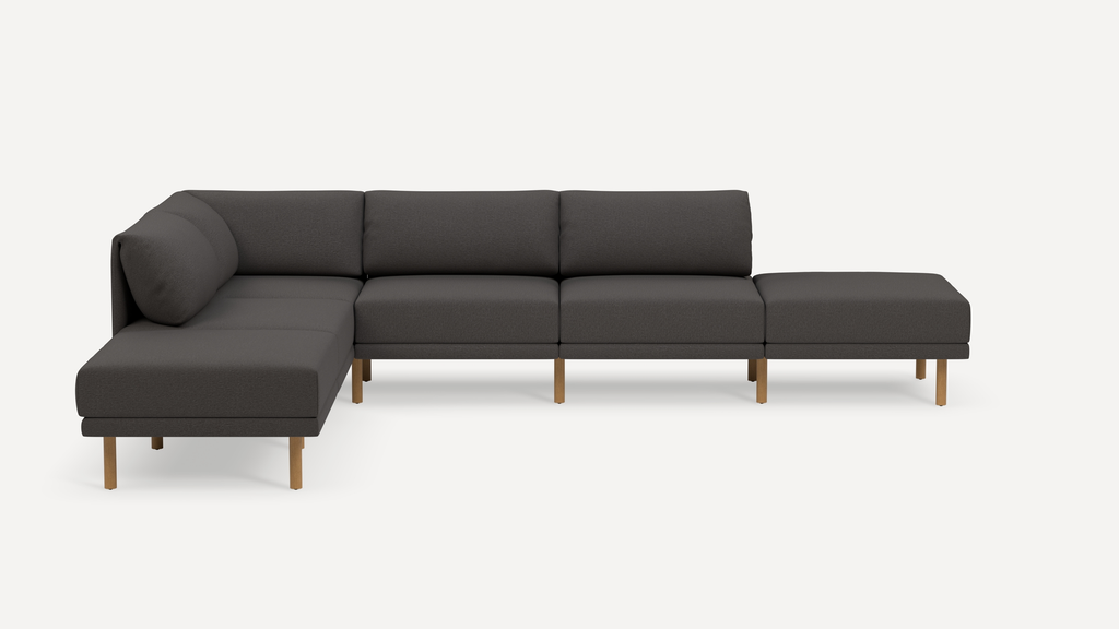 Modern dark gray fabric sectional sofa with wooden legs, featuring a left corner chaise and a right ottoman extension.