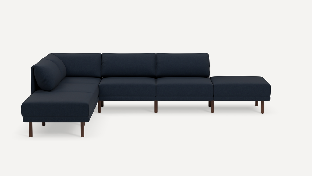 L-shaped modern sectional sofa in dark navy fabric with wooden legs and low backrest cushions.