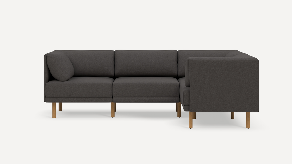 Modern dark gray fabric L-shaped sectional sofa with wooden legs and clean, minimalist design.