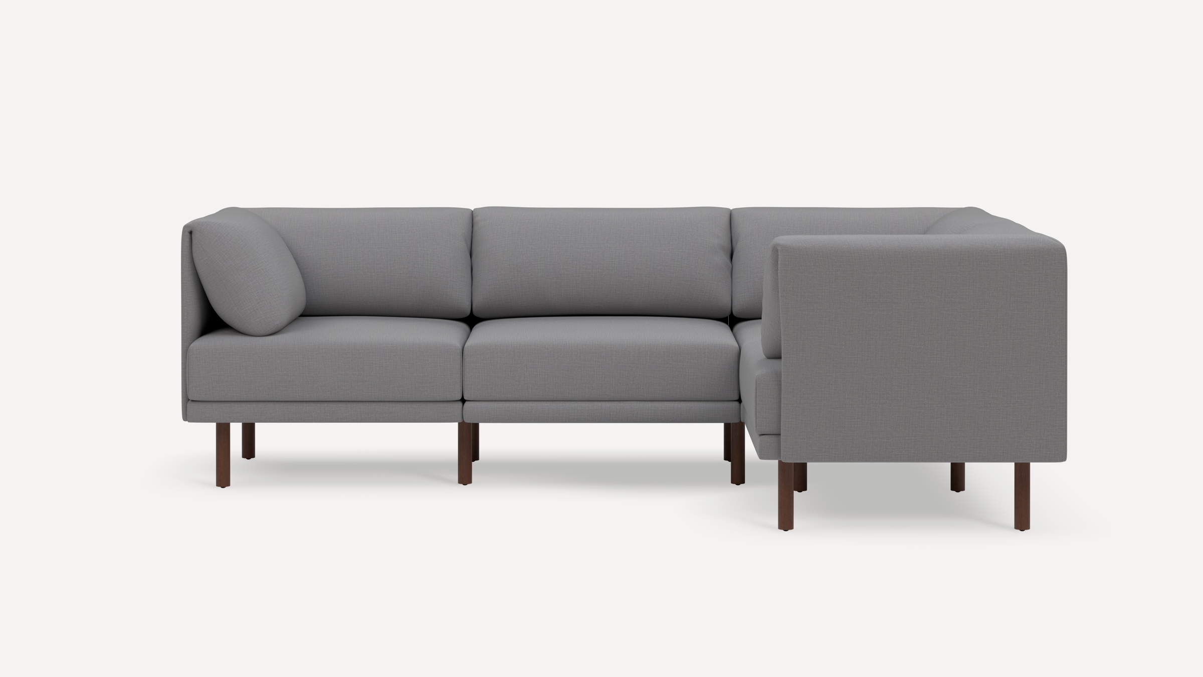 Modern gray L-shaped sectional sofa with wooden legs and plush back cushions, shown against a plain white background.