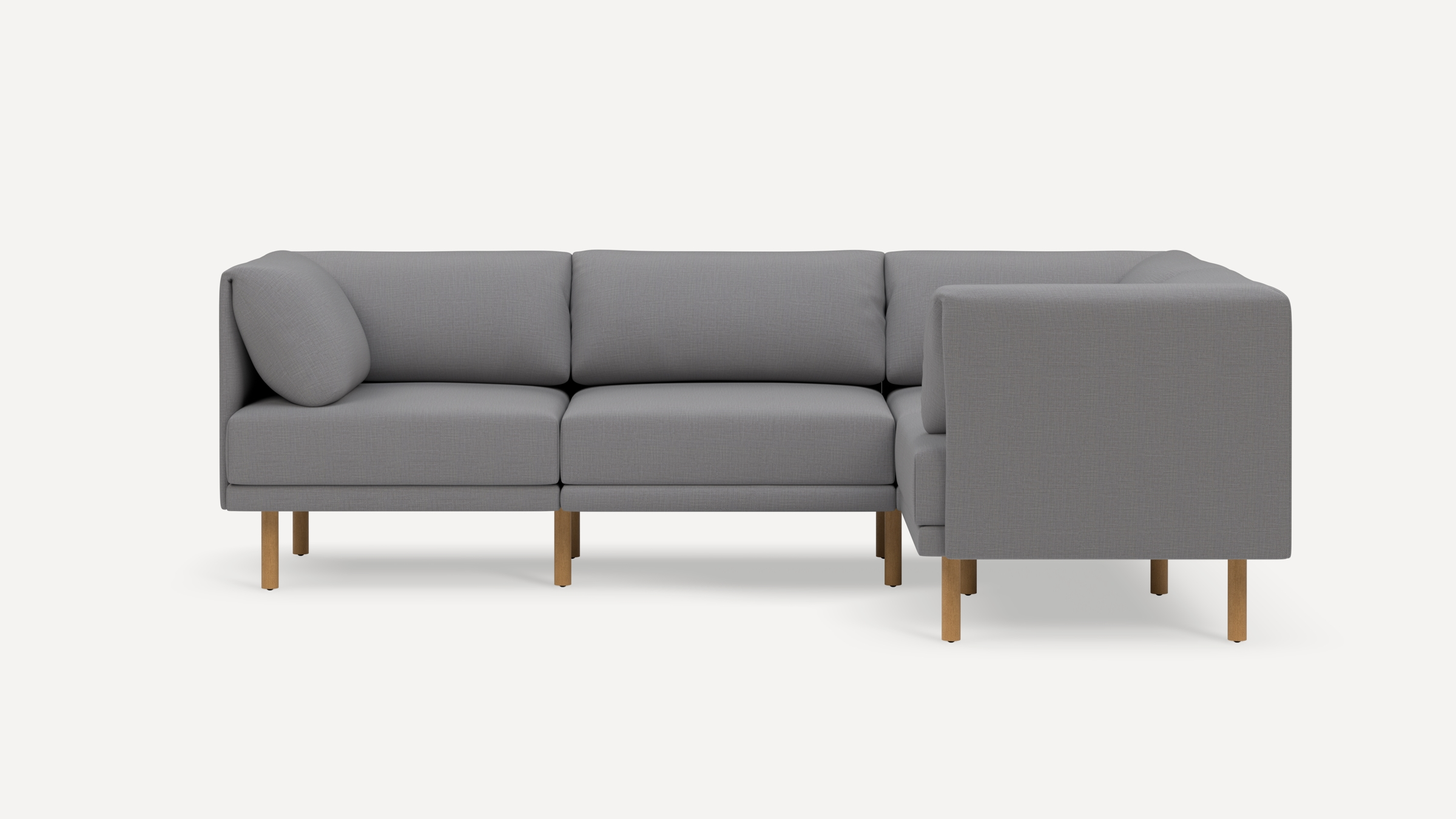 Modern L-shaped gray fabric sofa with wooden legs and cushioned backrests, displayed against a plain white background.