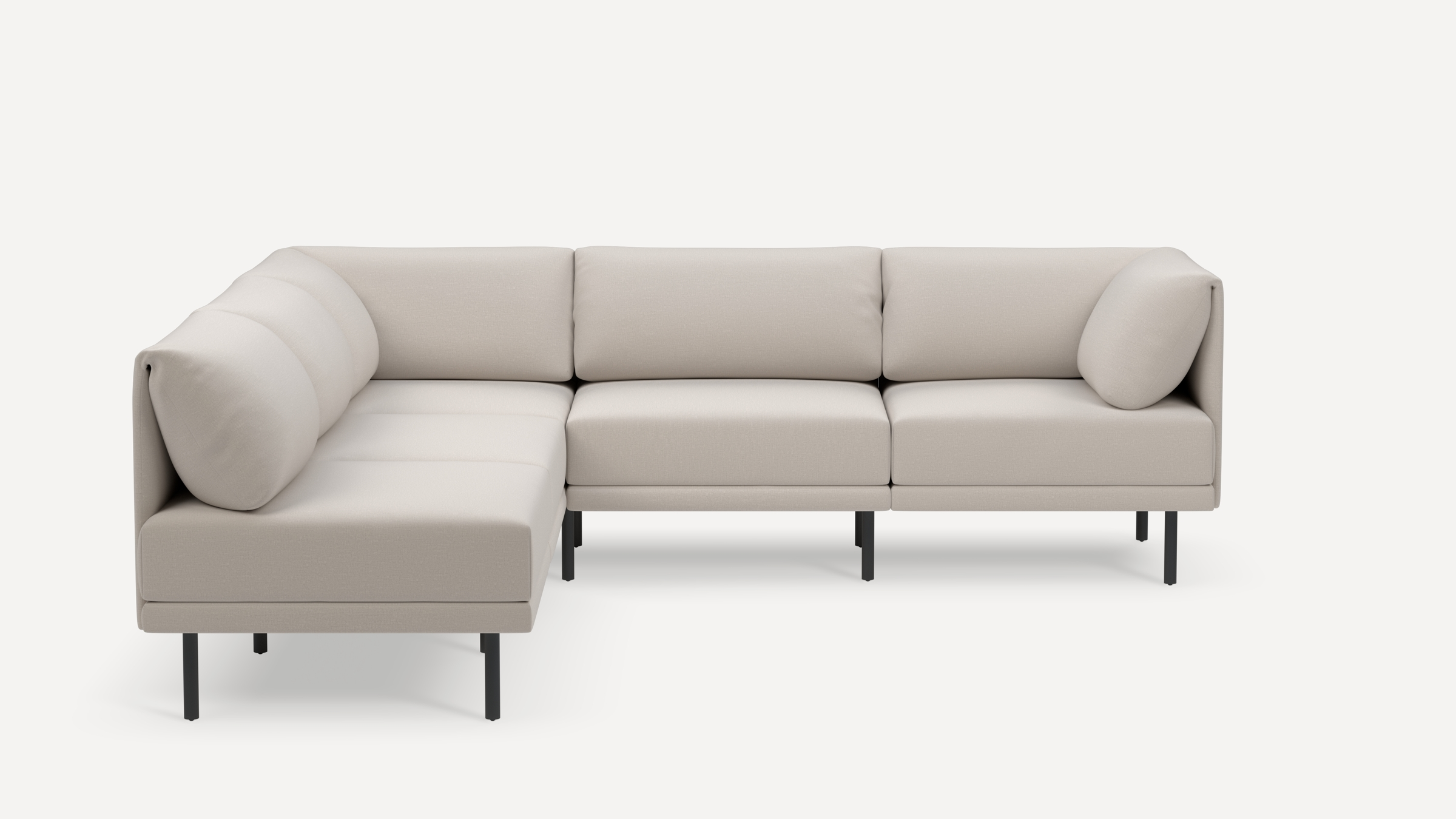 Modern L-shaped sectional sofa in light beige fabric with clean lines, plush cushions, and black slender metal legs.