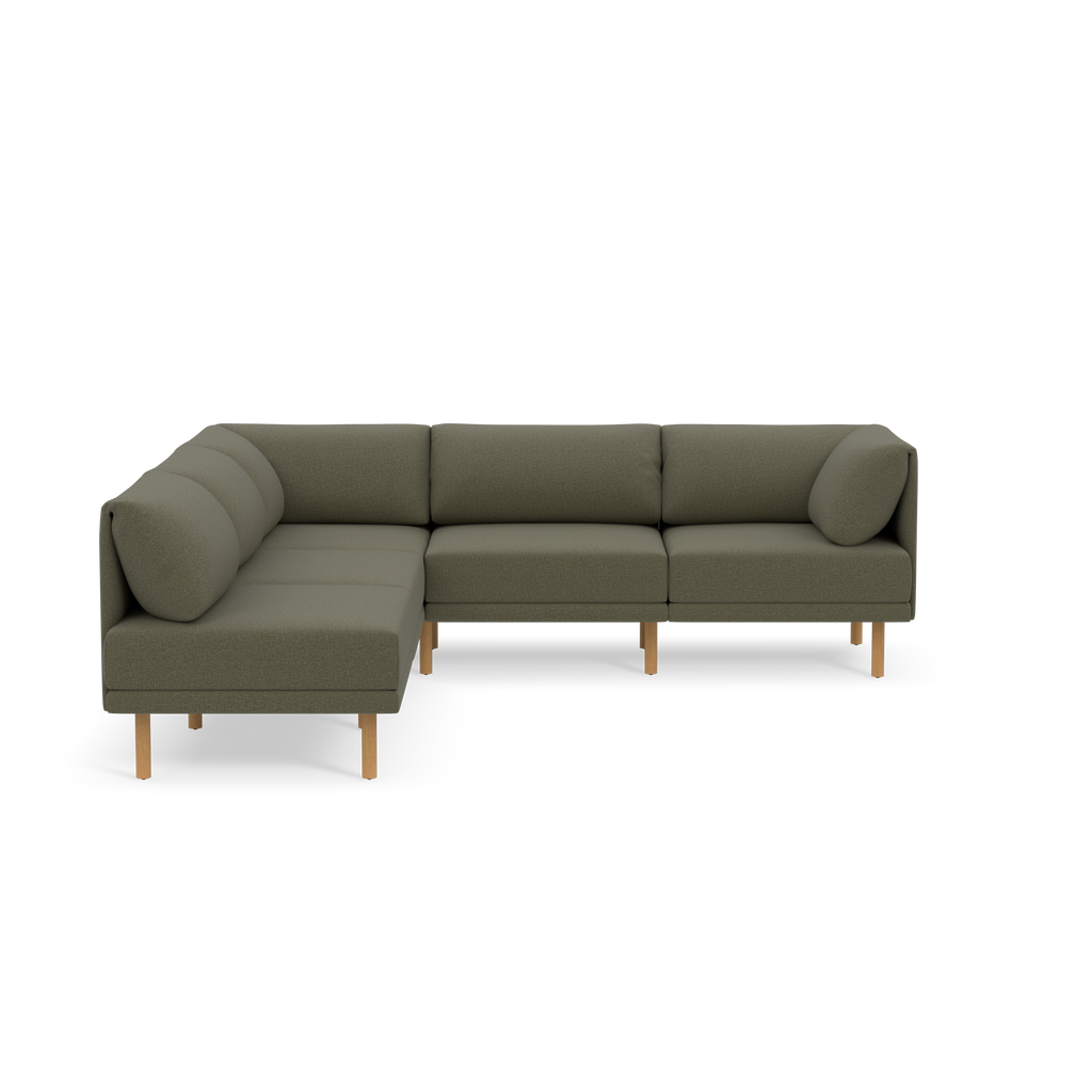 Modern L-shaped sectional sofa upholstered in Moss green fabric with wooden legs and plush back cushions, set against black background.