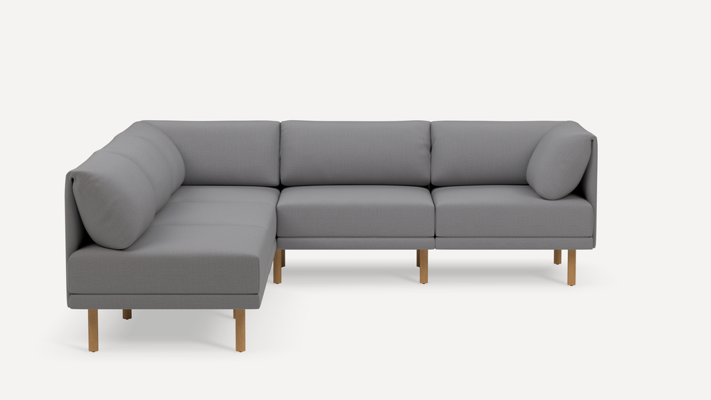 Modern L-shaped sectional sofa with light gray fabric upholstery and wooden legs, featuring cushioned backrests and armrests.