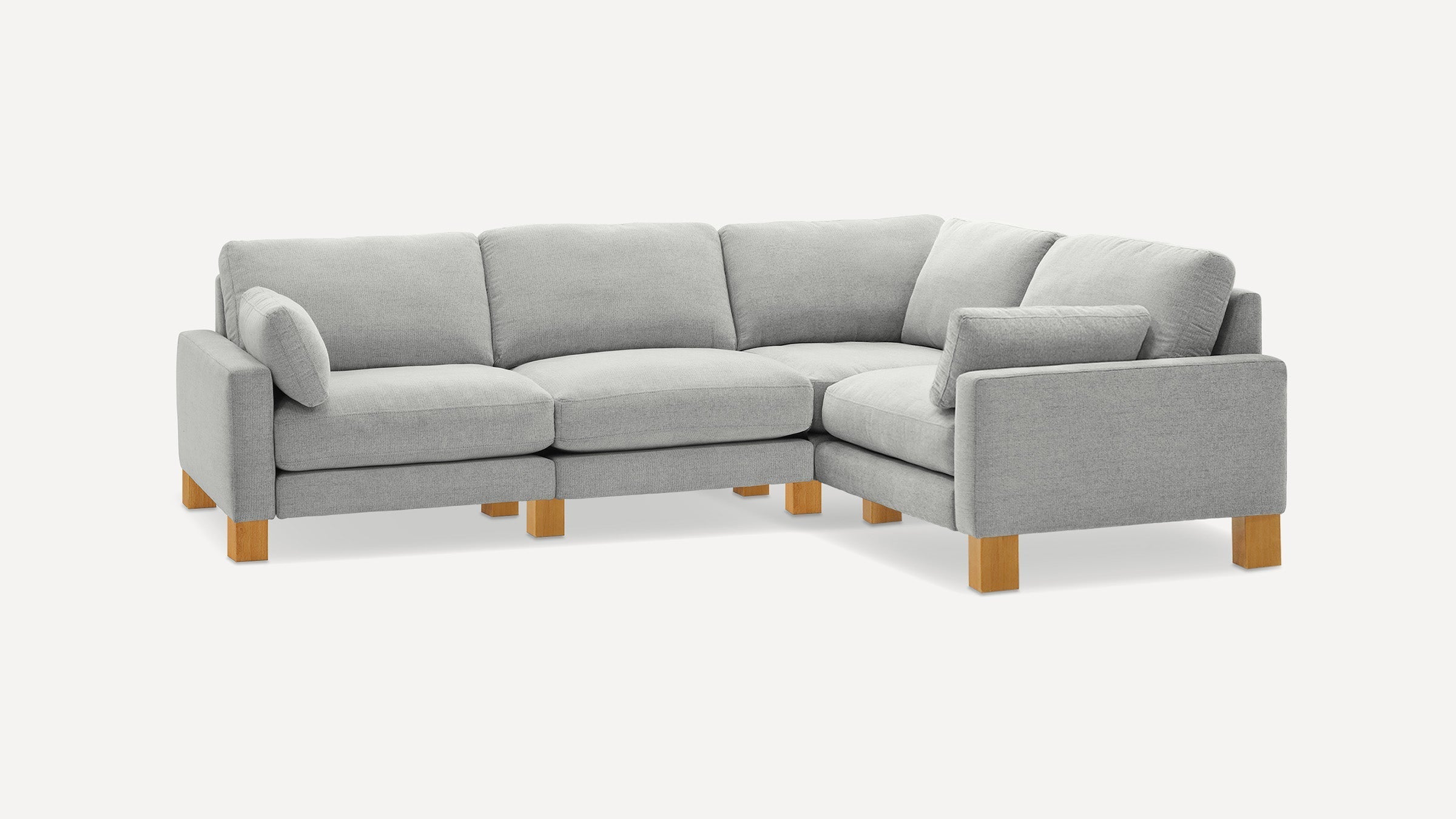 Light gray L-shaped sectional sofa with wooden legs and plush cushions, minimalist modern design.