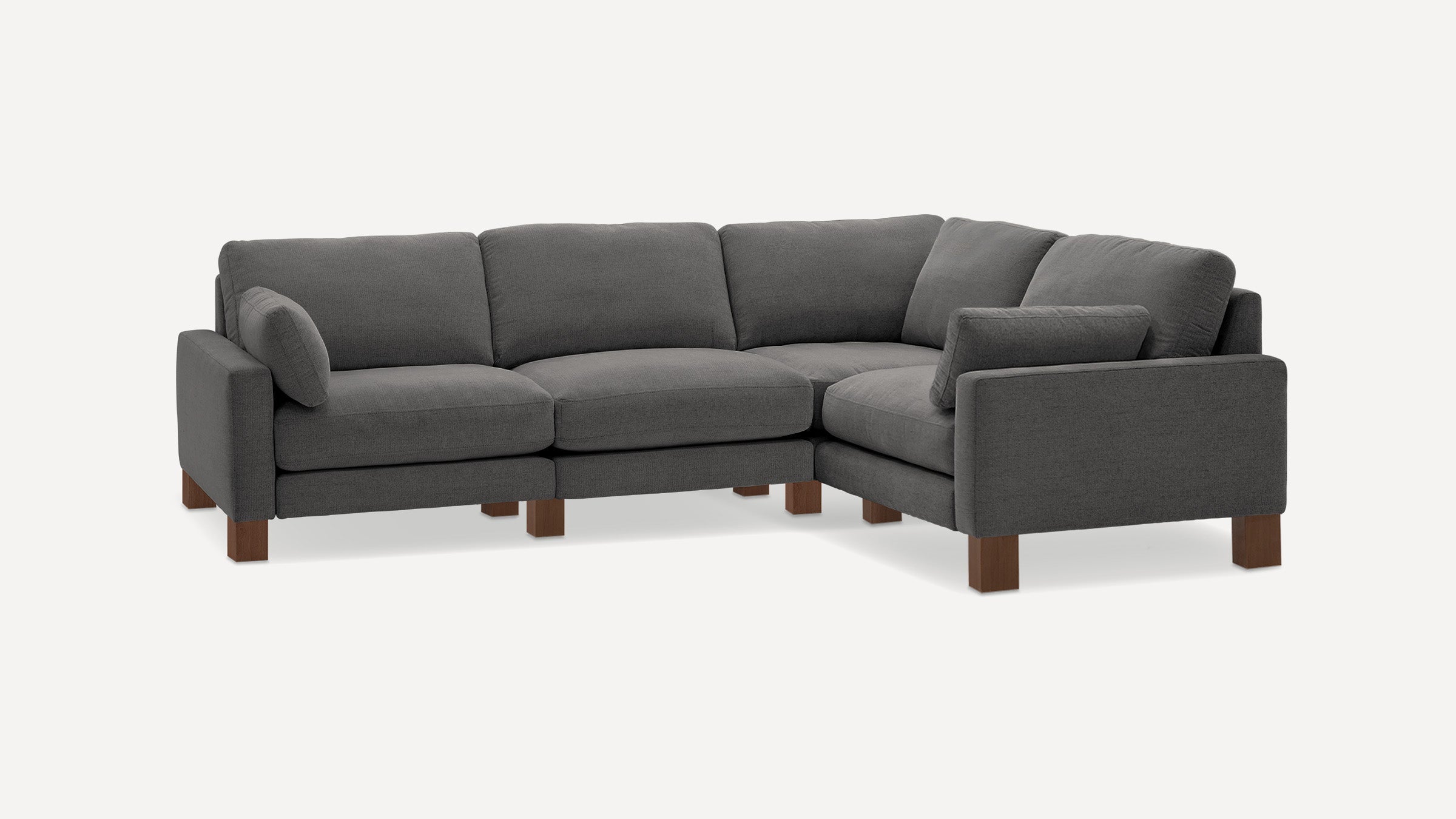 Dark gray fabric L-shaped sectional sofa with wooden block legs and matching cushions on each side.