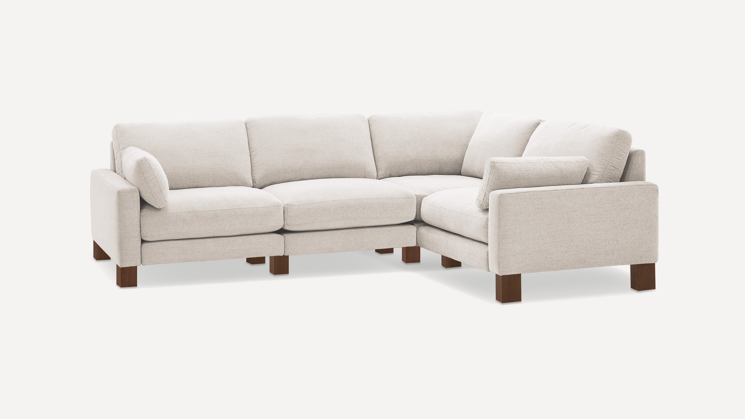 Light beige L-shaped sectional sofa with soft cushions and dark wooden legs, designed for modern living rooms.