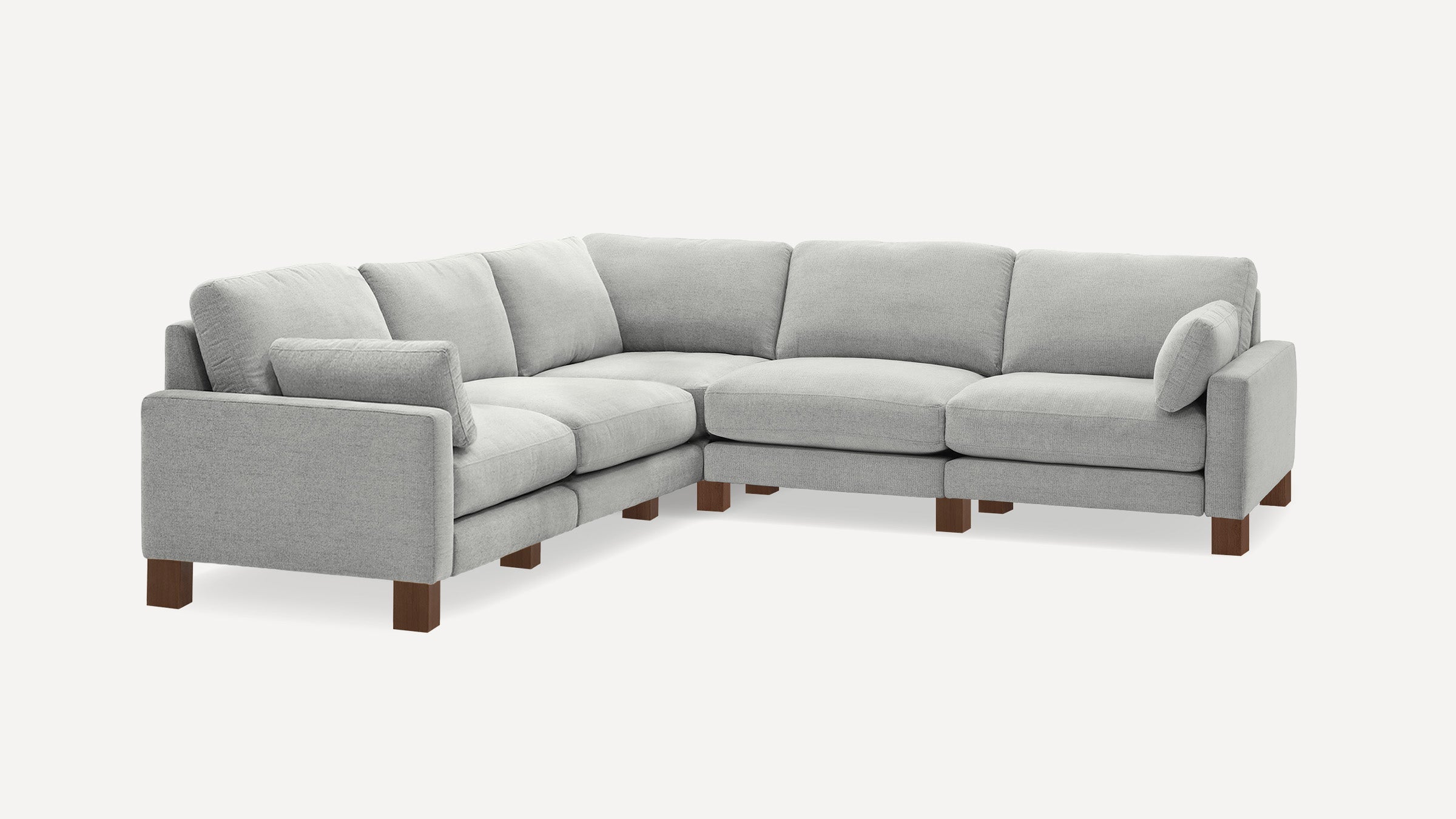 Light gray L-shaped sectional sofa with wooden legs and multiple cushioned seats and backrests.