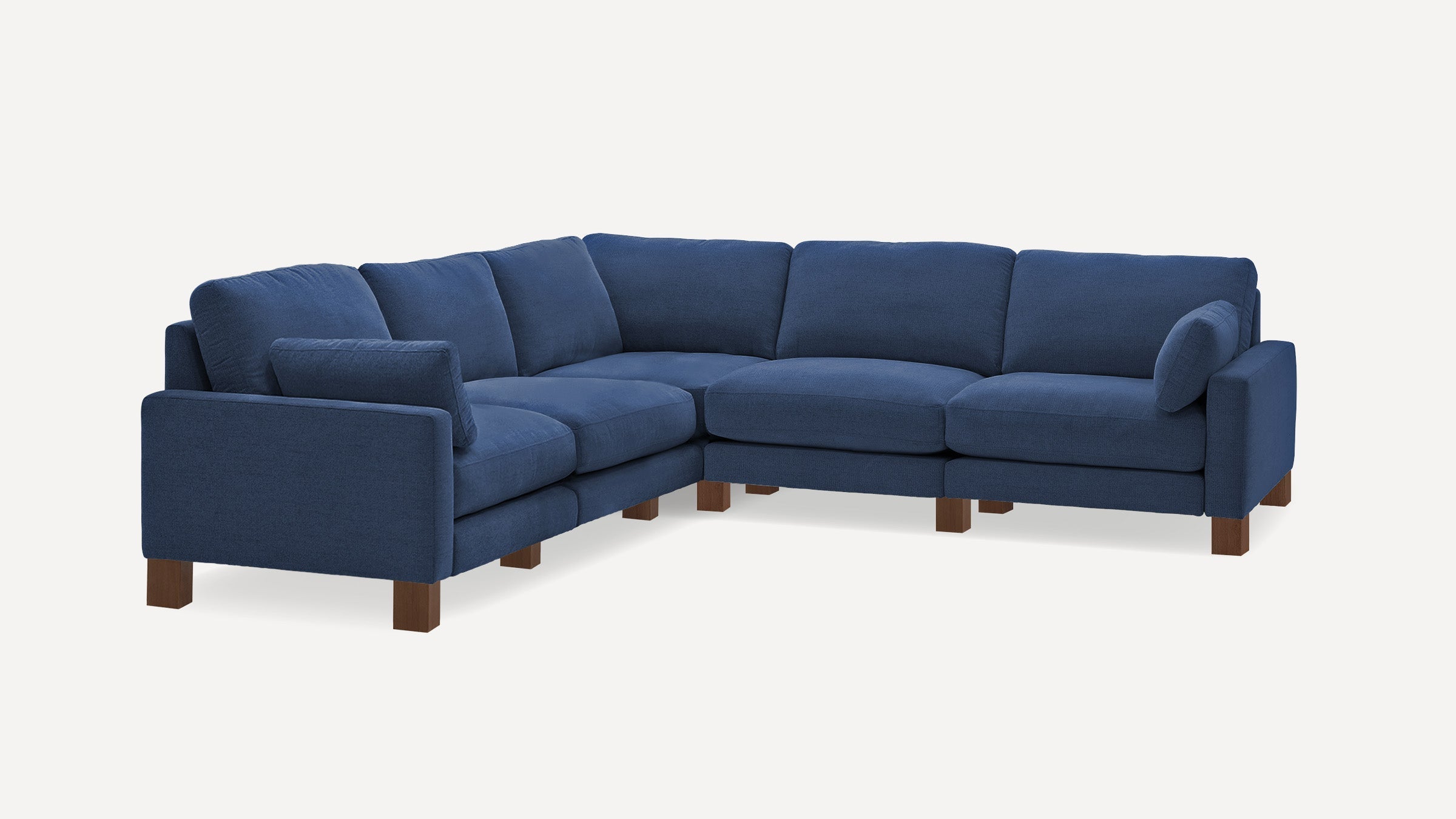 L-shaped sectional sofa with deep blue fabric upholstery, wooden legs, and plush cushions for comfortable seating.