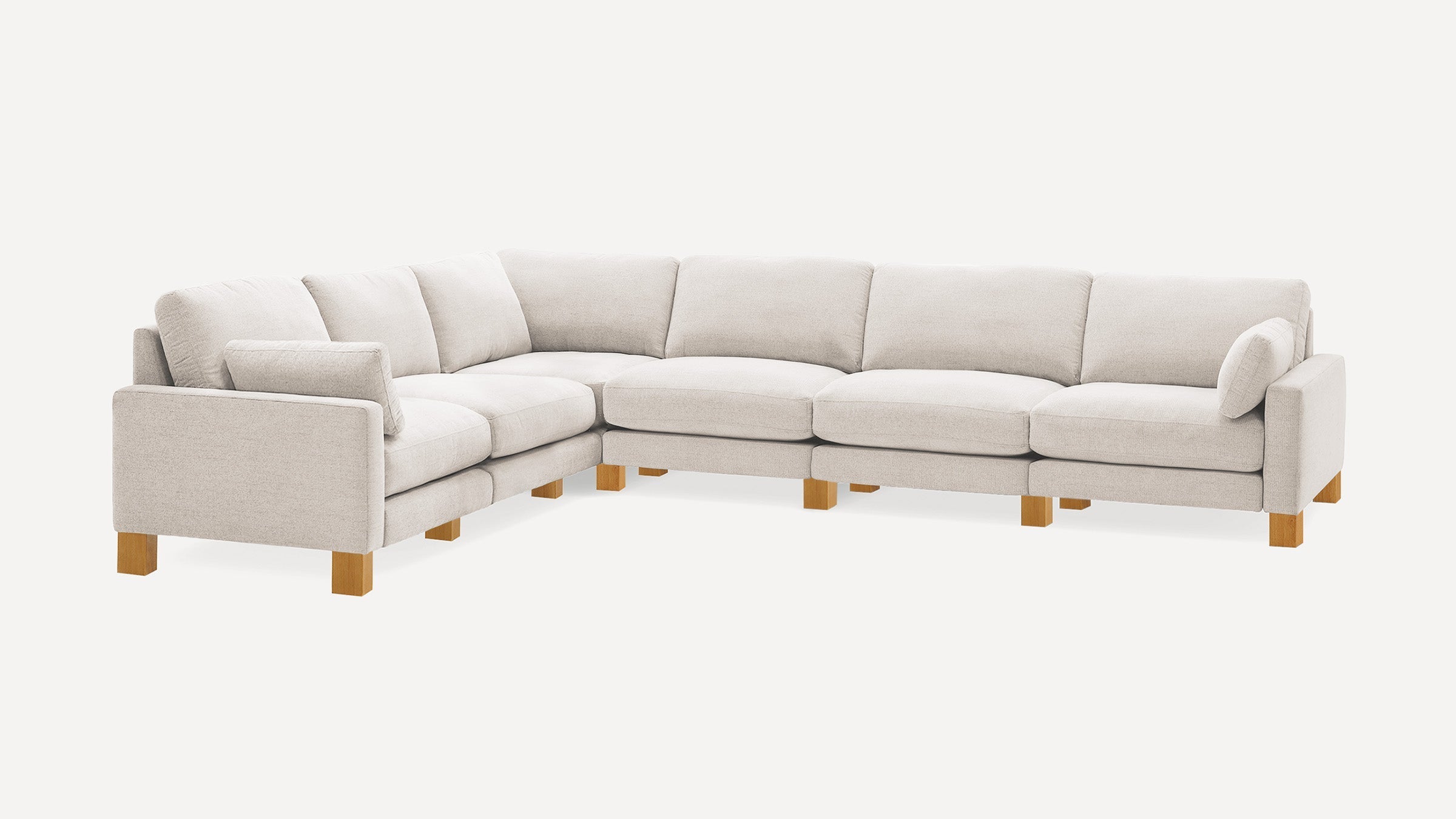 Light beige sectional sofa with wooden legs, cushioned seats, backrests, and armrests, shown on white background.