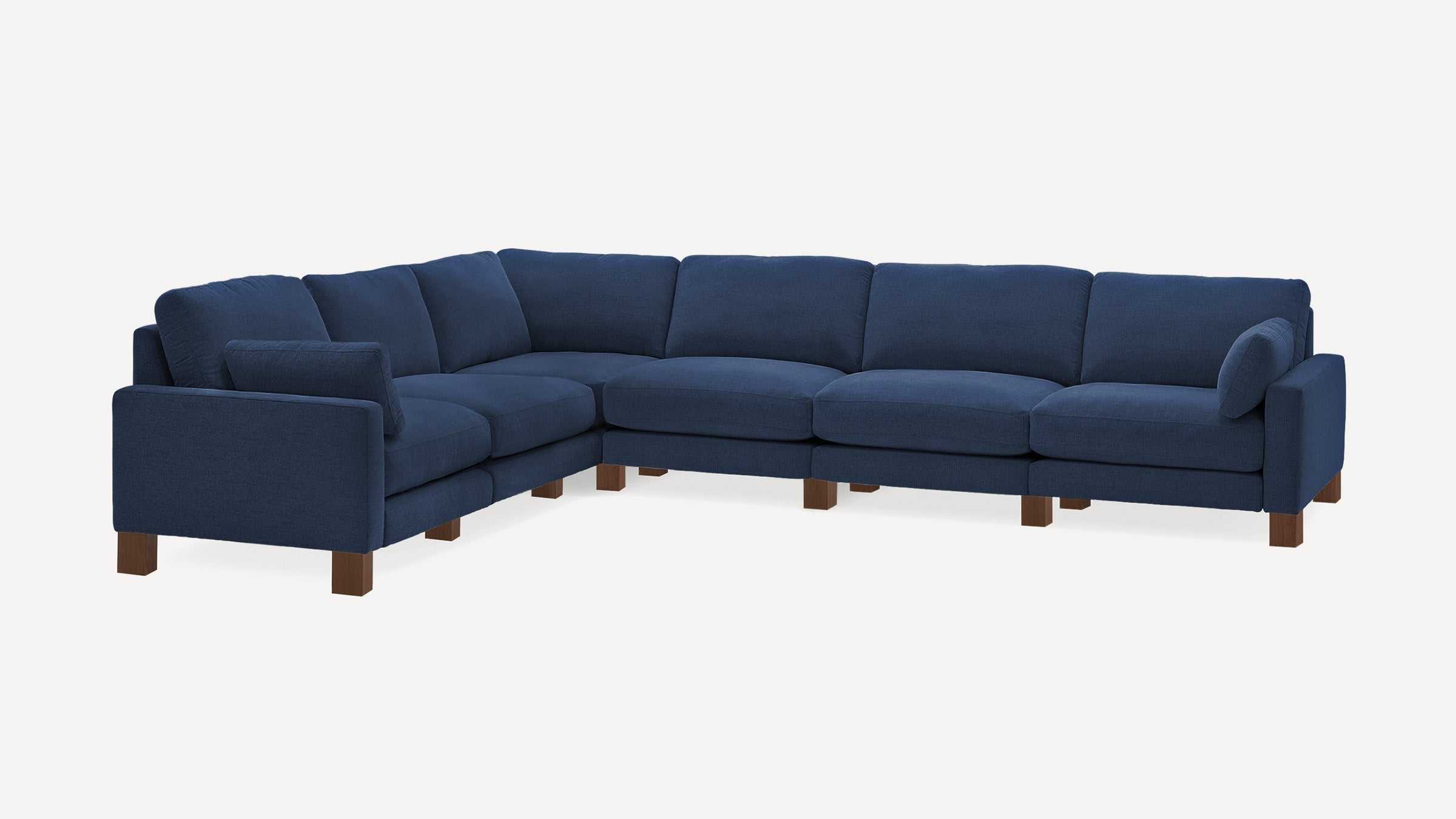 Large modern navy blue sectional sofa with wooden block legs and plush cushions on a white background.