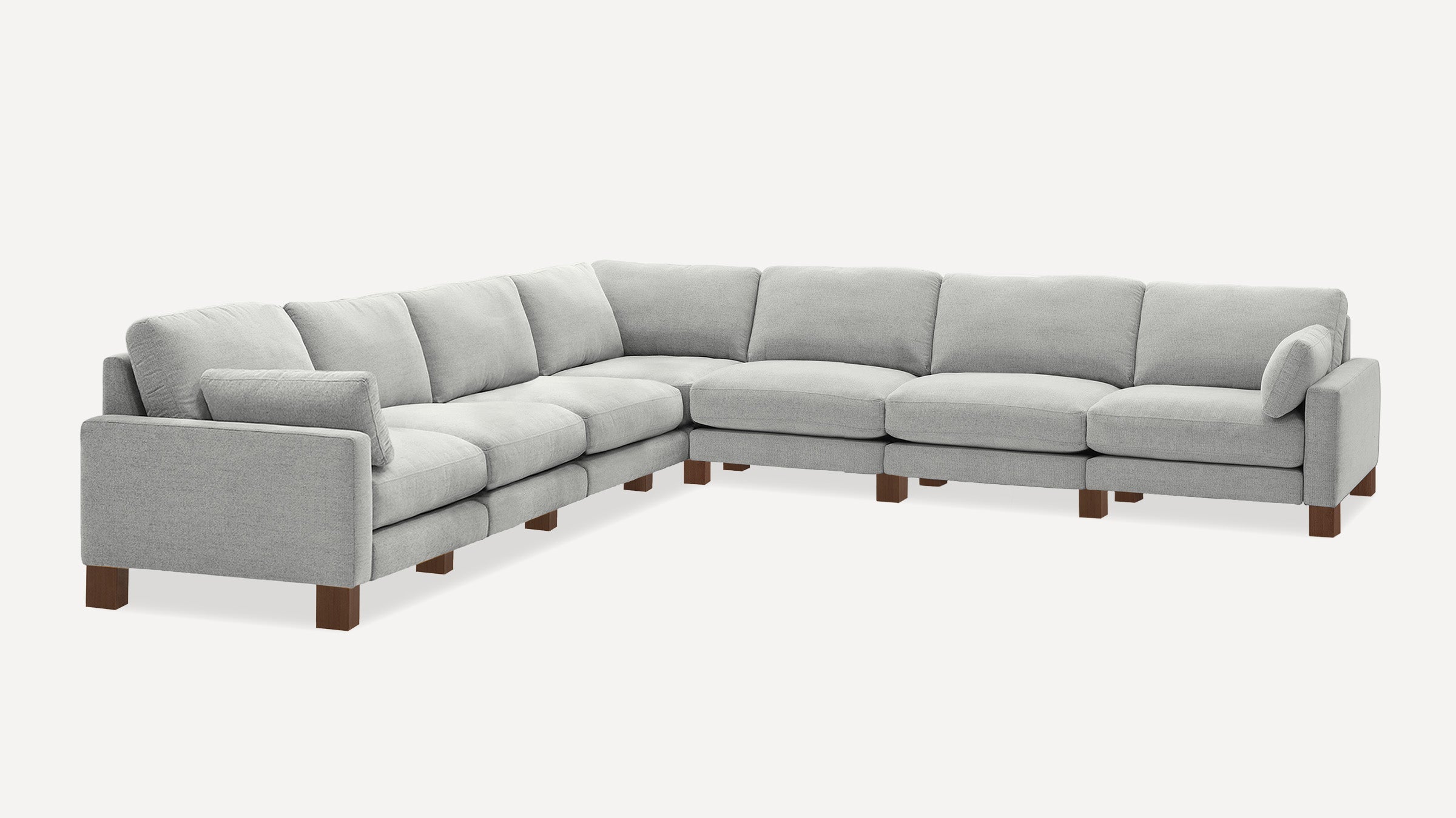 Large light gray L-shaped sectional sofa with soft cushions, wooden legs, and a modern minimalist design.