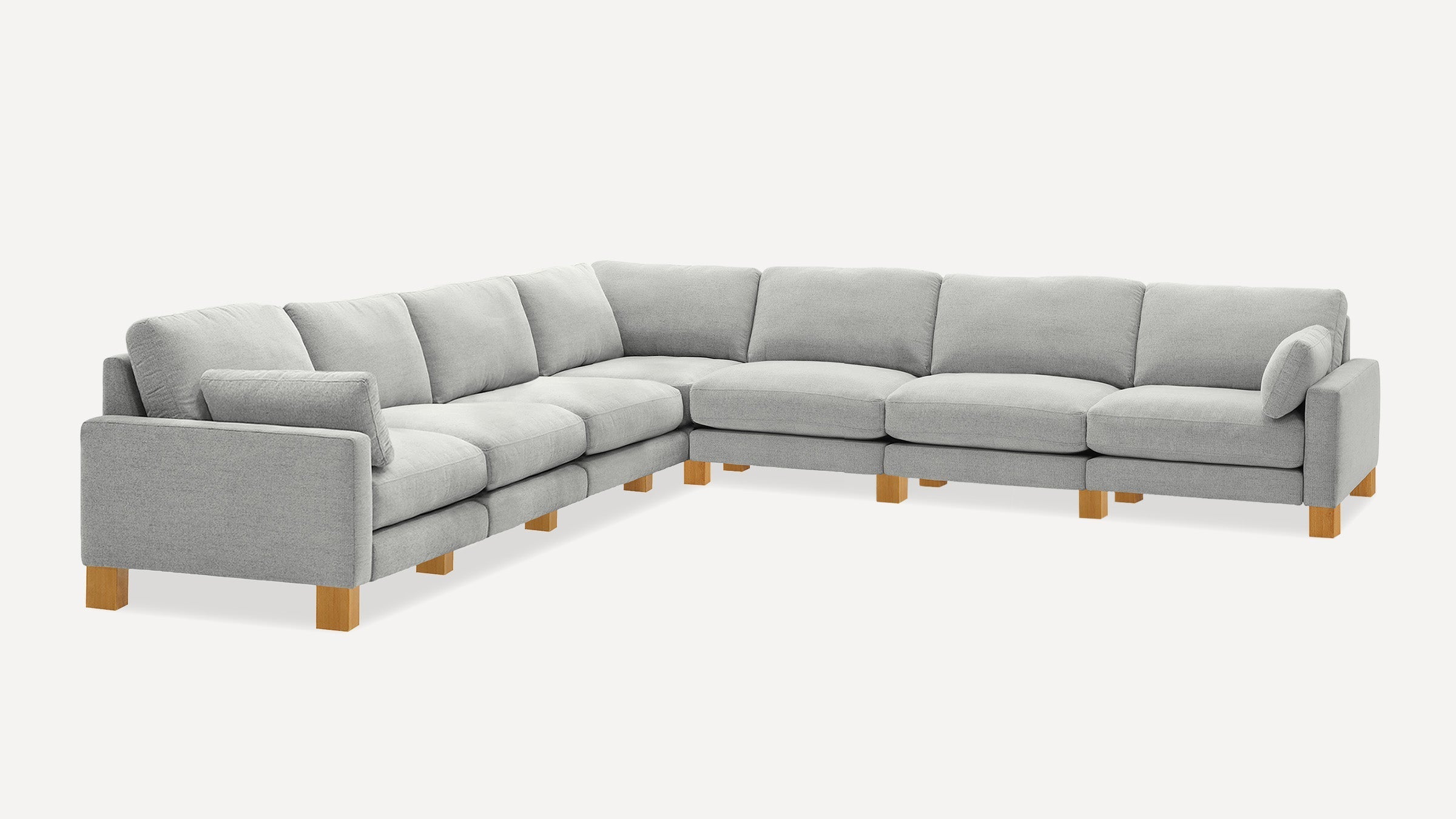 Large light gray L-shaped sectional sofa with soft cushions and wooden block legs on a white background.