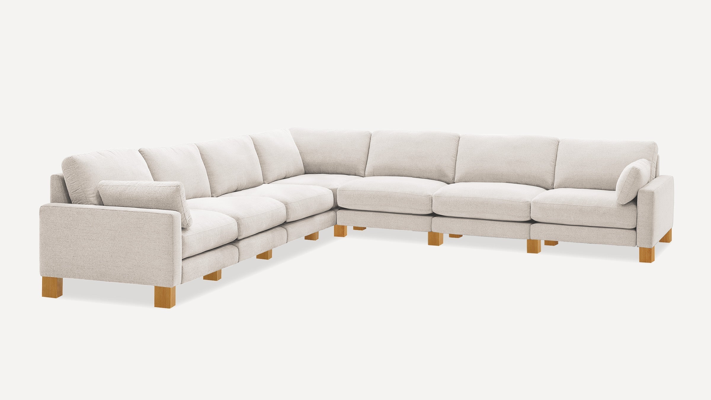 Large light beige fabric sectional sofa with wooden legs, featuring multiple cushioned seats and armrests on both ends.